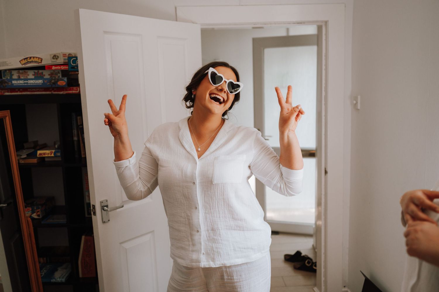 A candid celebratory moment showing peace signs and joy in a white button-up shirt.
