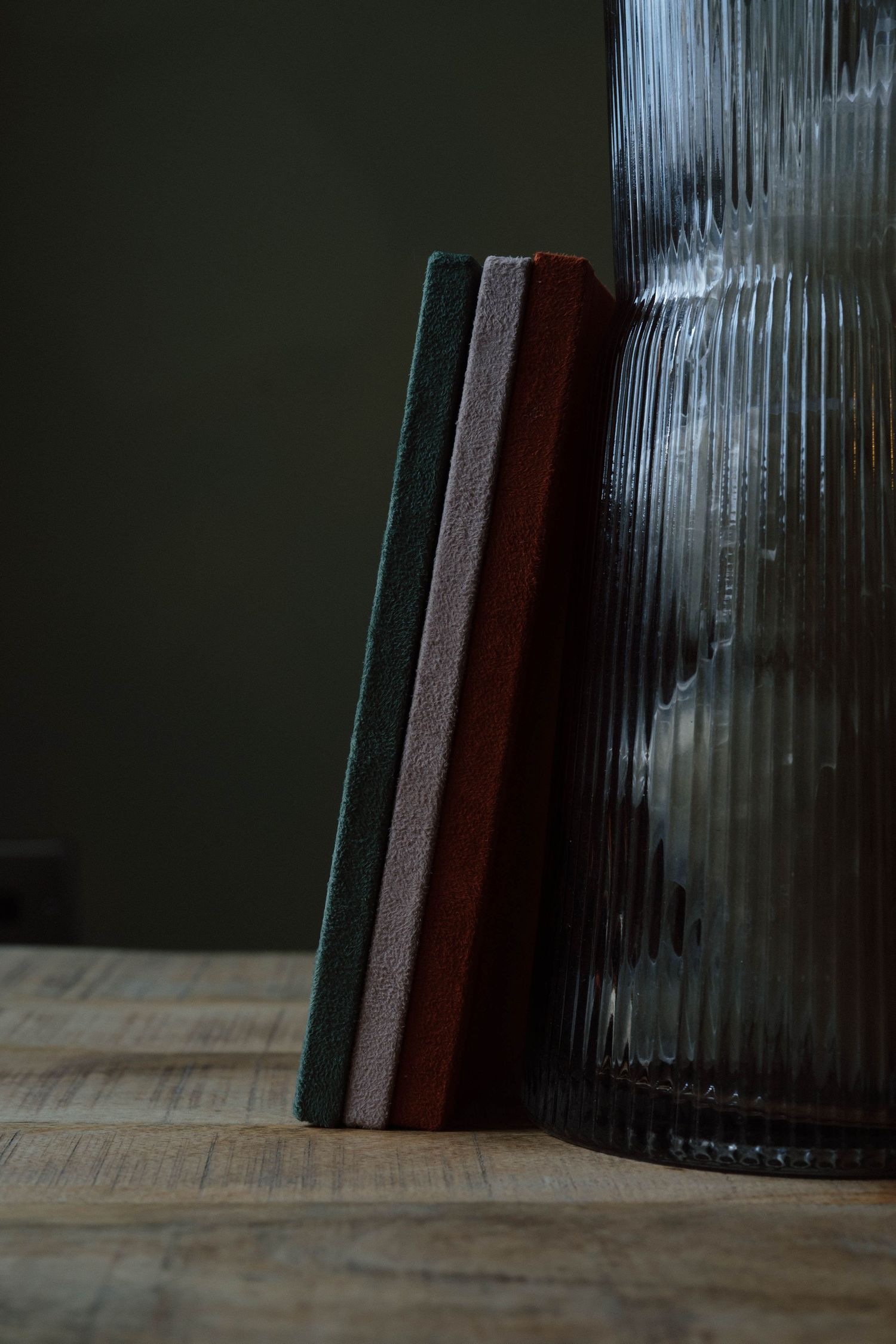 Leather-bound photo albums with textured covers arranged vertically against a dark background.