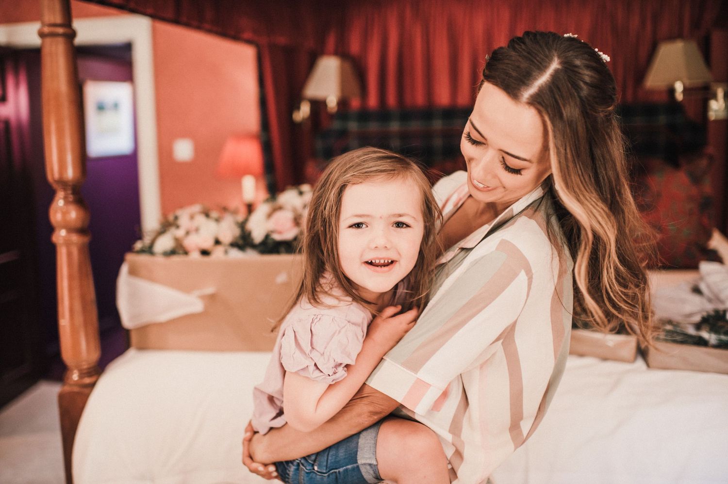 A joyful moment of connection captured on a bed with warm lighting.