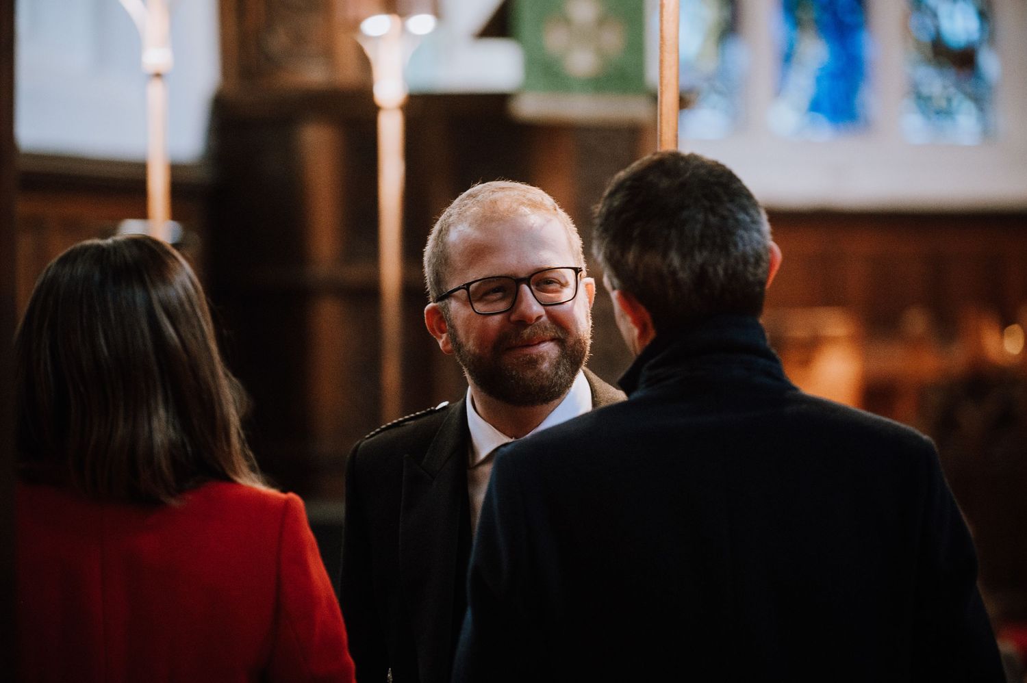 Small group having a conversation in a warm-lit church interior.