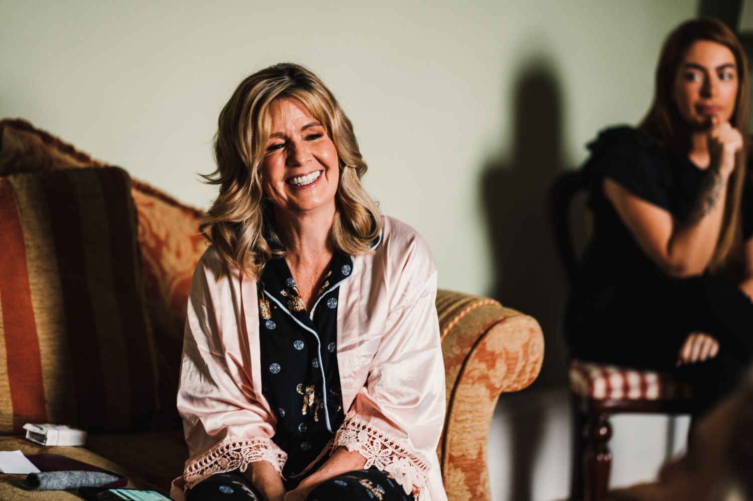 A casual moment captured during wedding preparations on a vintage couch.