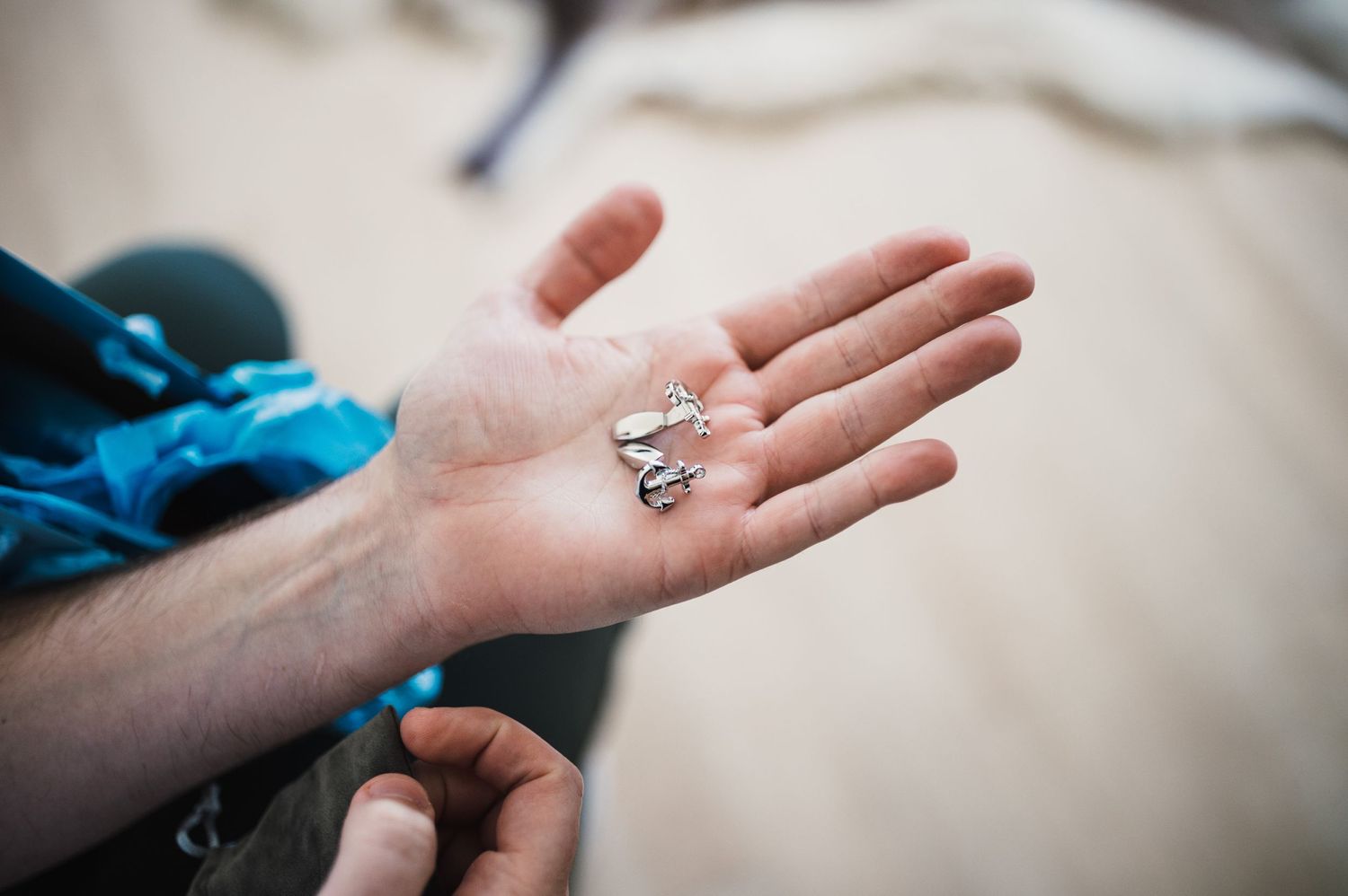 An open palm holding small silver rings against a light background.