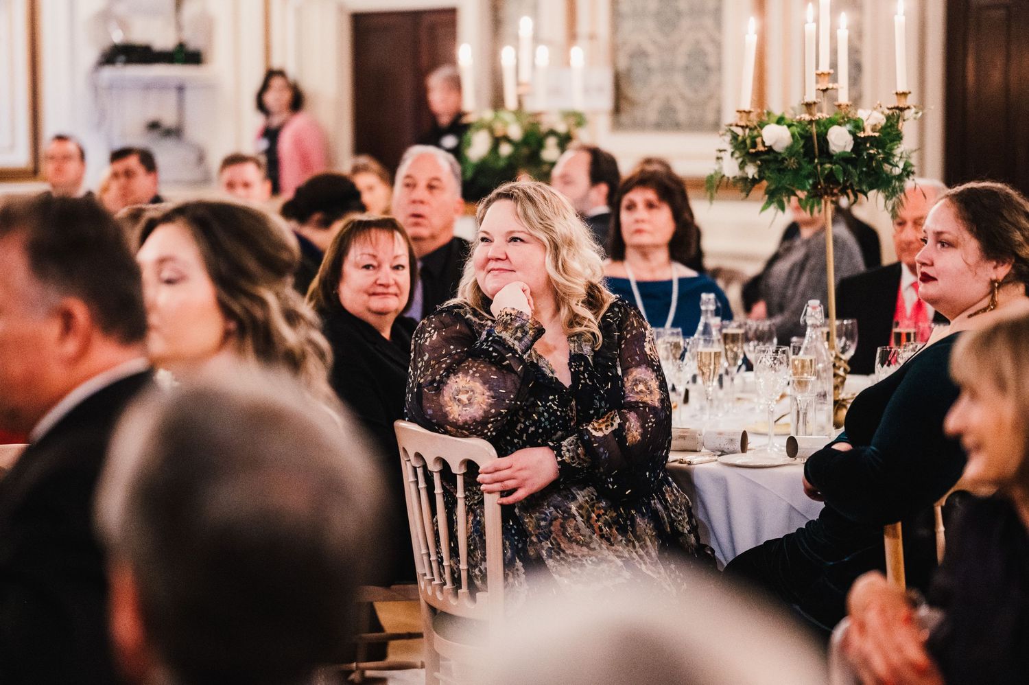 Wedding guests laugh and enjoy themselves during an elegant evening reception.
