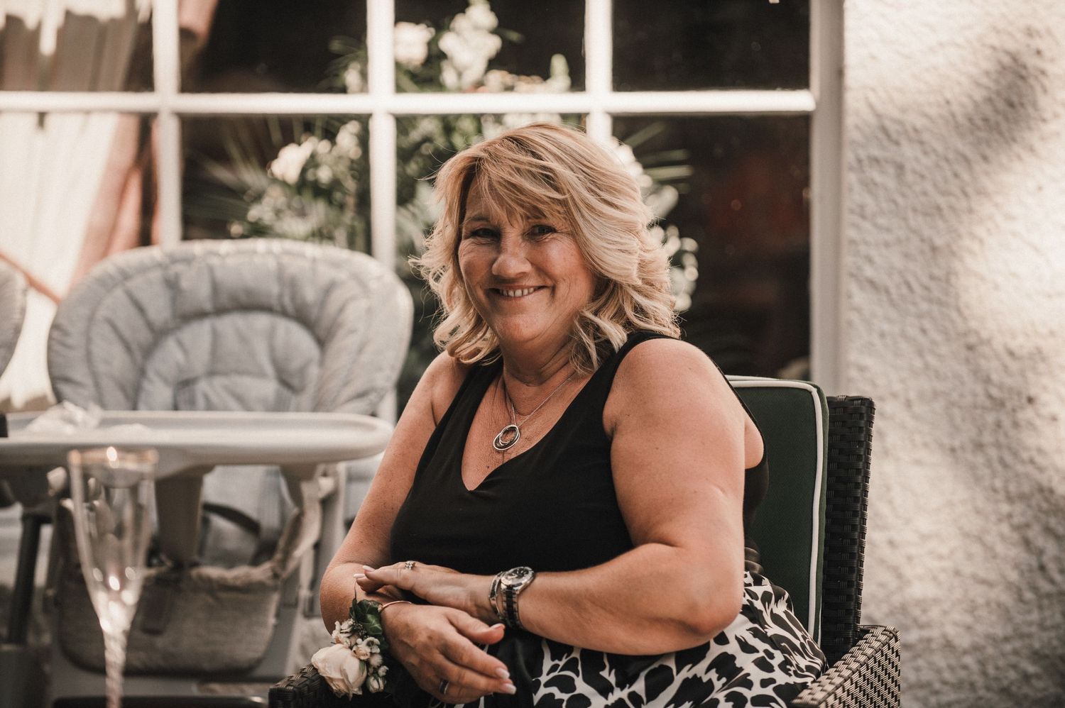 Woman in black dress enjoying herself at an outdoor wedding reception.