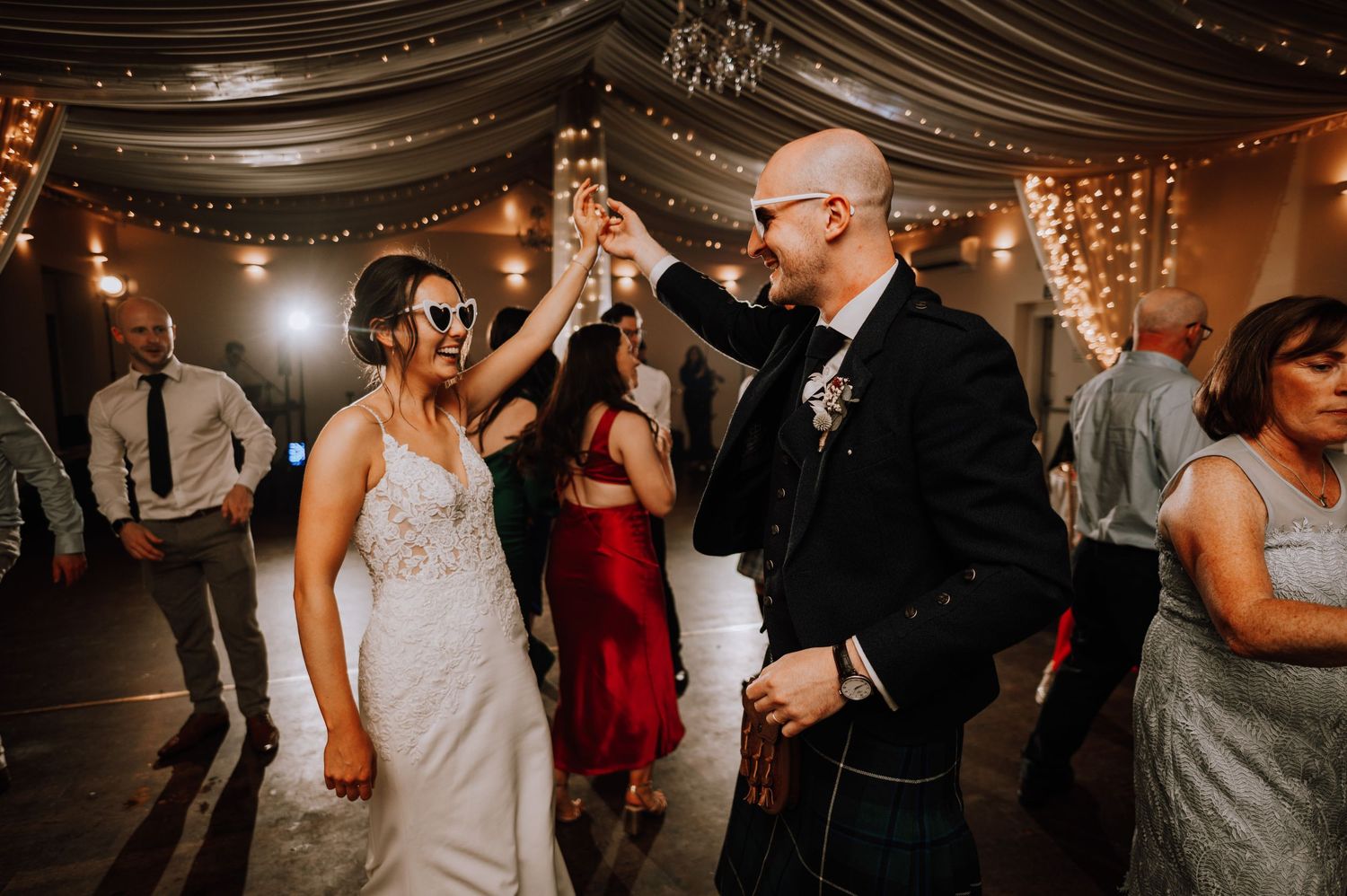 Aberdeen Wedding Photography. Wedding reception venue decorated with elegant draped fabric and twinkling lights overhead.