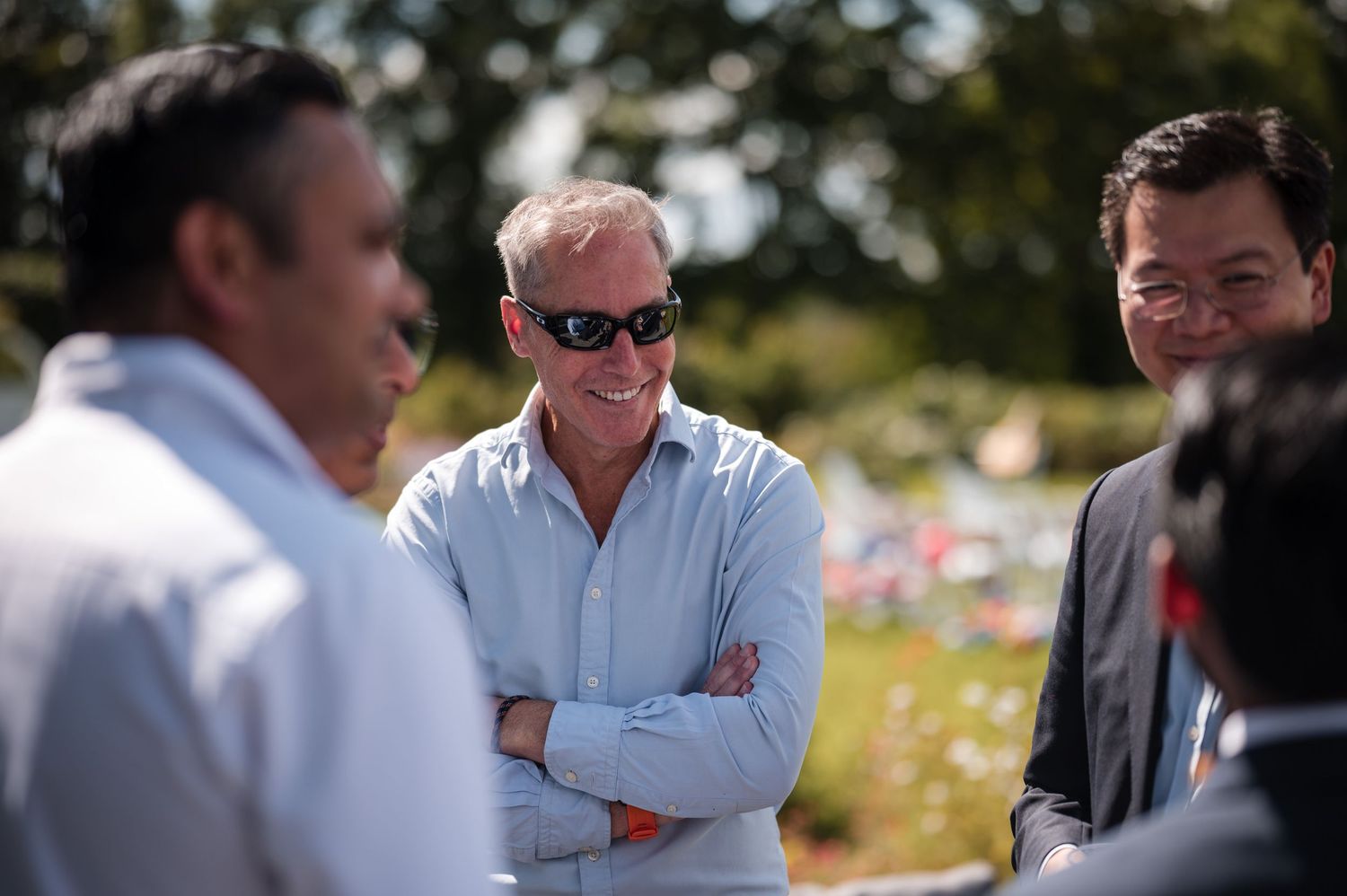 Guests mingling outdoors at a casual daytime event.