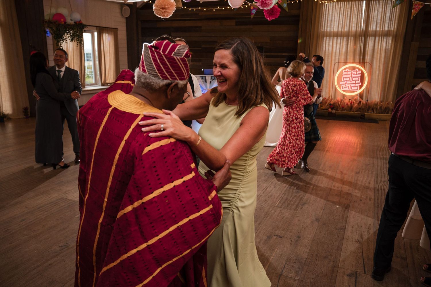 Wedding reception dance floor moments with guests celebrating in a warmly lit venue.
