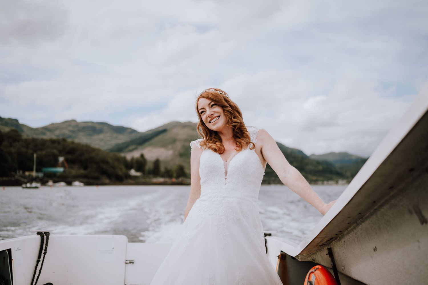 A scenic lakeside wedding photo with rolling hills and waters in the background.