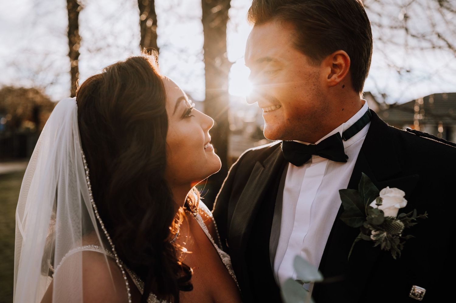 A sunlit wedding portrait capturing an intimate moment between newlyweds.