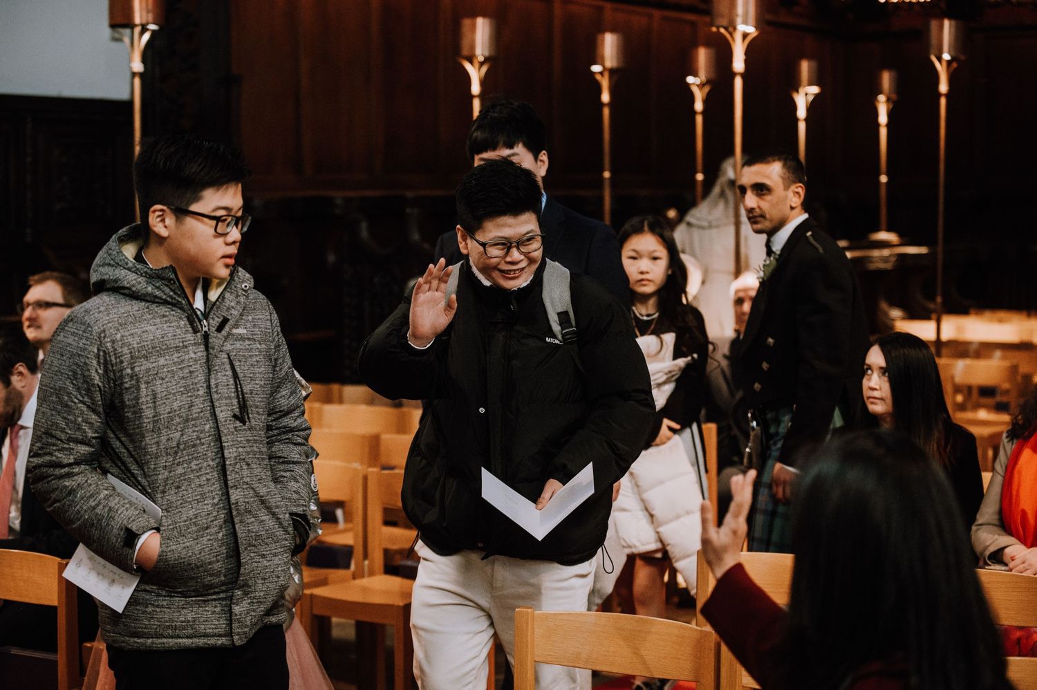 Group of casually dressed people gathered in a church with candlelit backdrop.