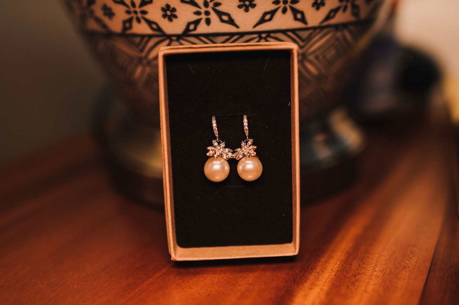 Pearl drop earrings displayed in an elegant black jewelry box.