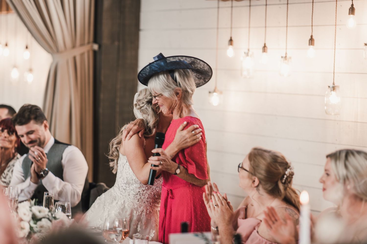 Emotional wedding reception moment captured during speeches and toasts.
