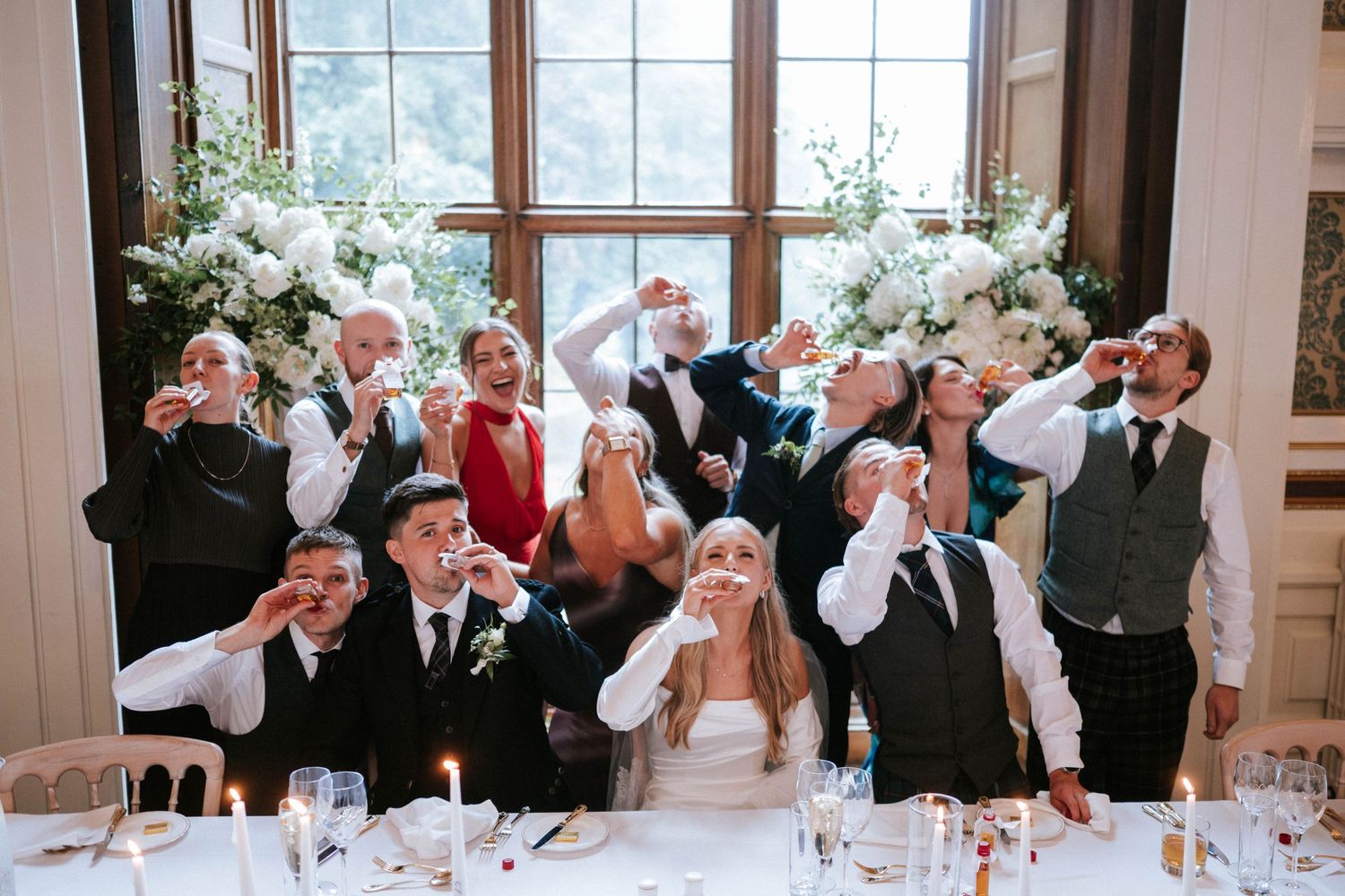 Guests wave white napkins in unison during a joyous wedding reception celebration.