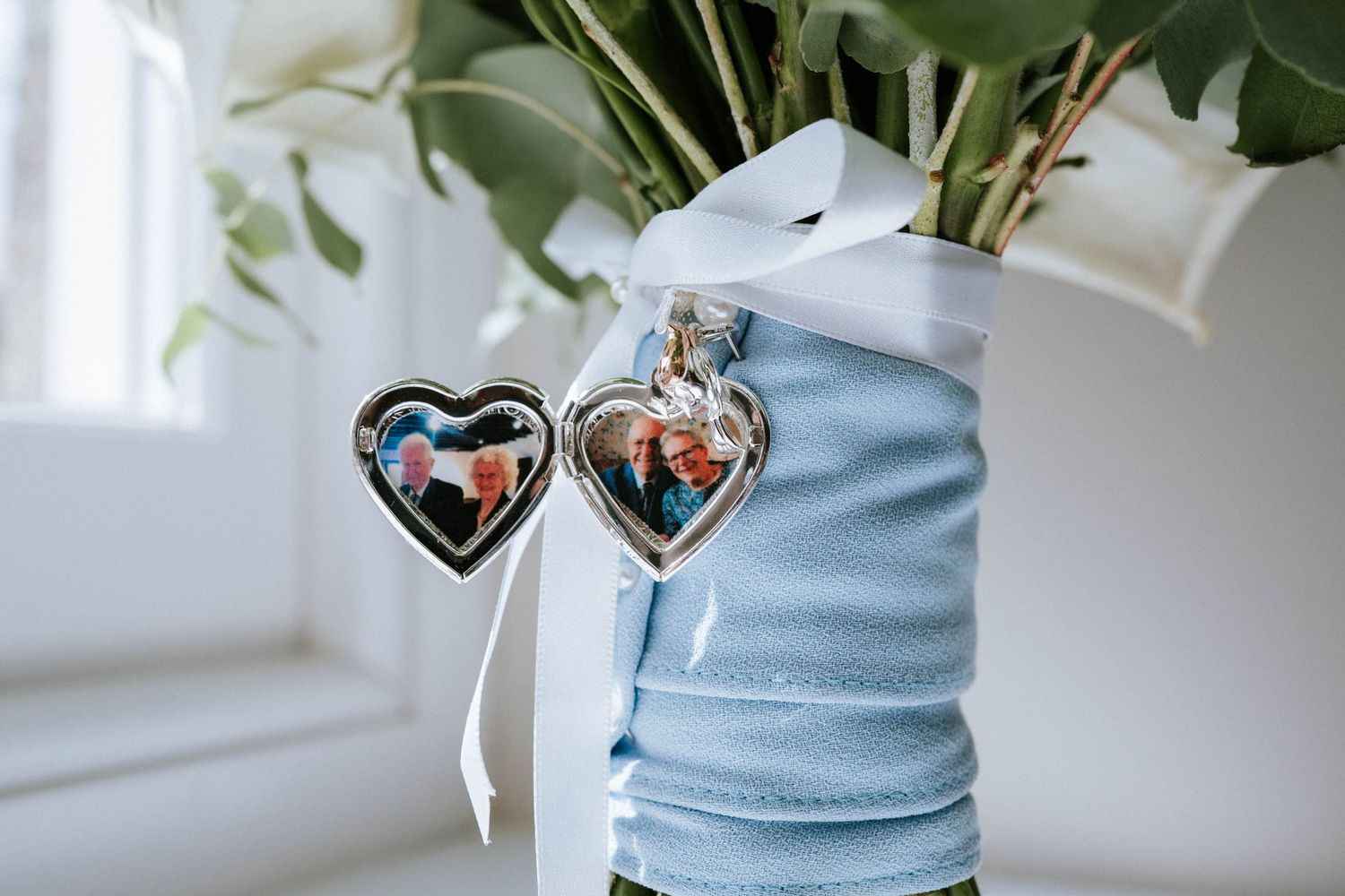 Wedding accessories including heart-shaped lockets and blue fabric details in soft focus.
