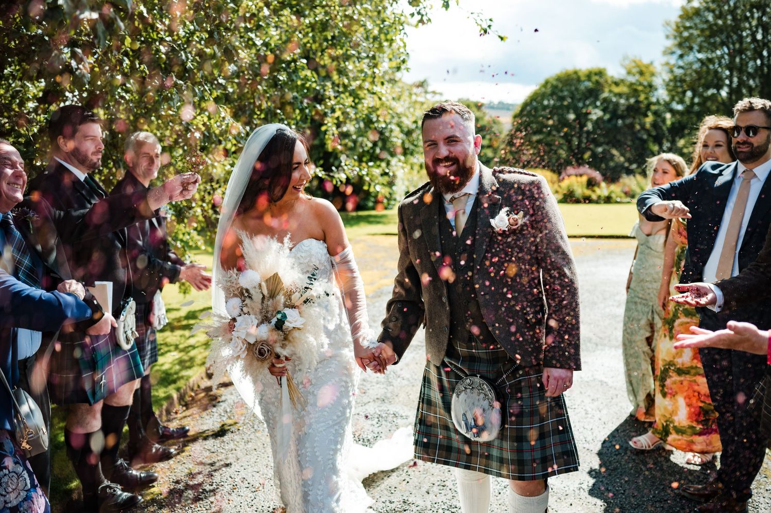 Aberdeen Wedding Photography. Wedding guests celebrate with confetti and laughter during an outdoor summer celebration.