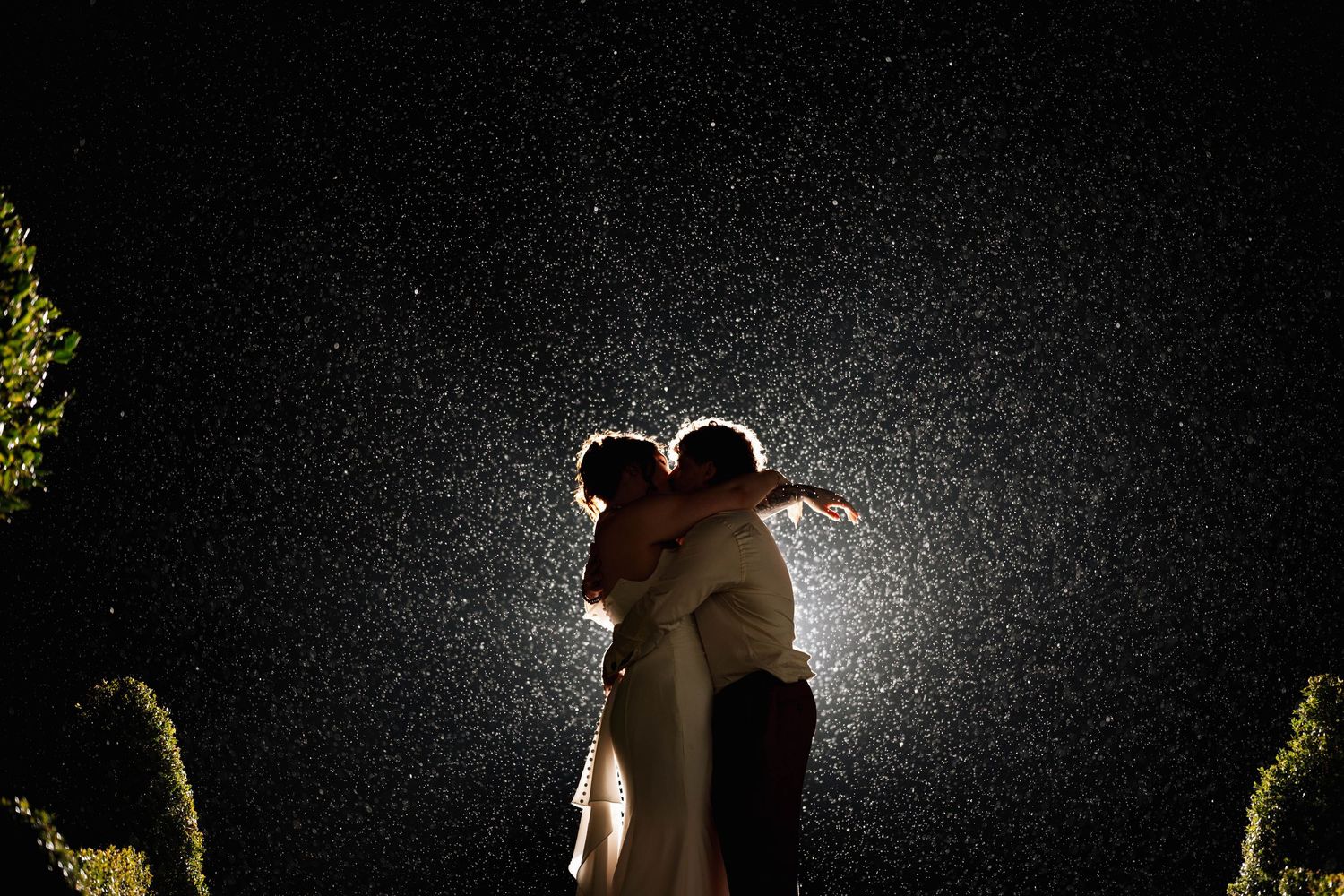 A romantic couple dances together in silhouette against a dark background with dramatic lighting effects.