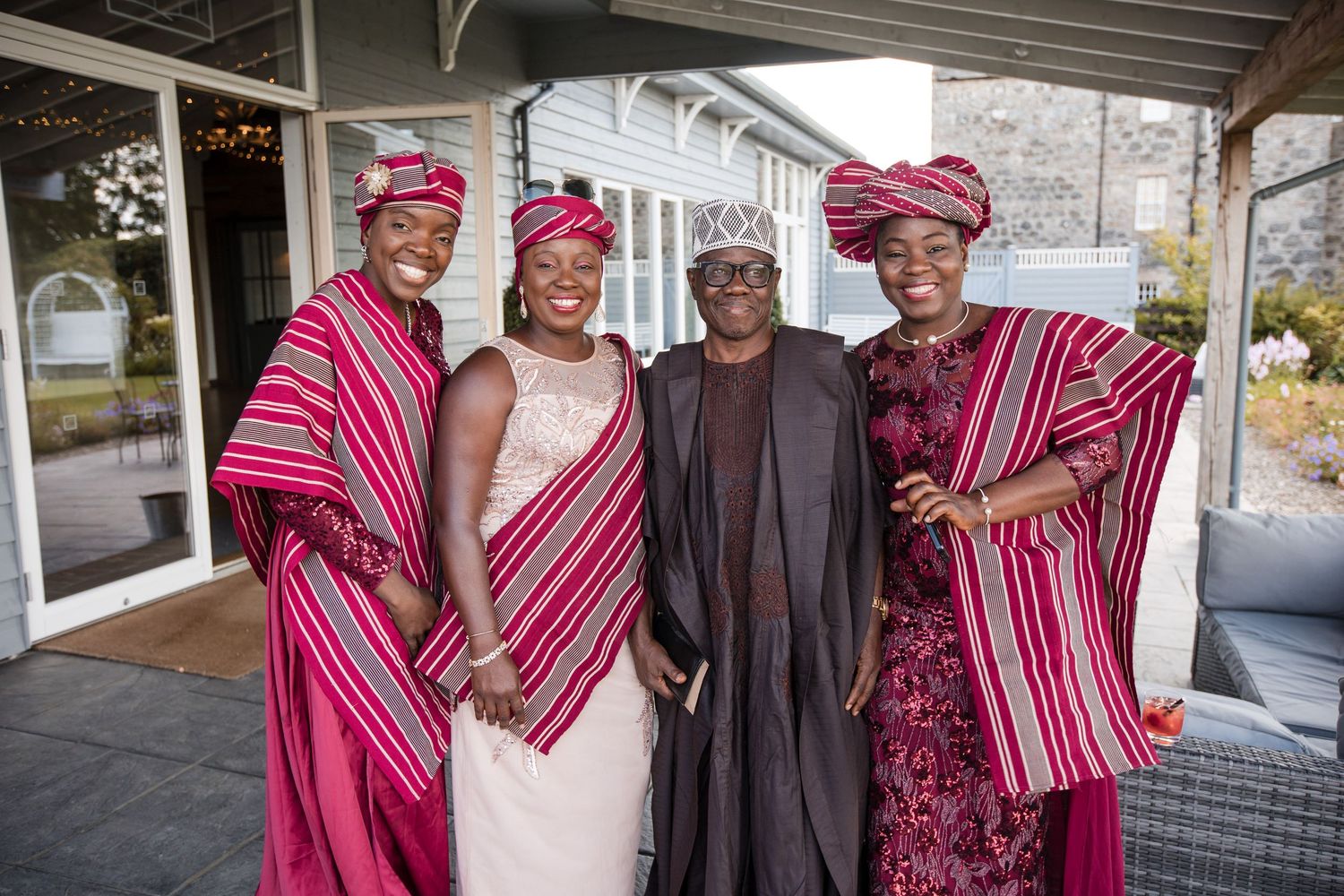 Group wearing vibrant pink and red striped traditional garments posing together.