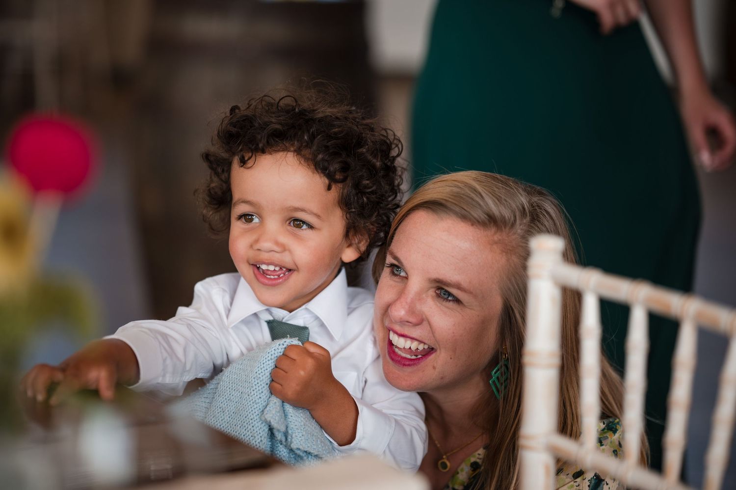 Candid reception moments show guests laughing and enjoying festivities at indoor wedding venue.