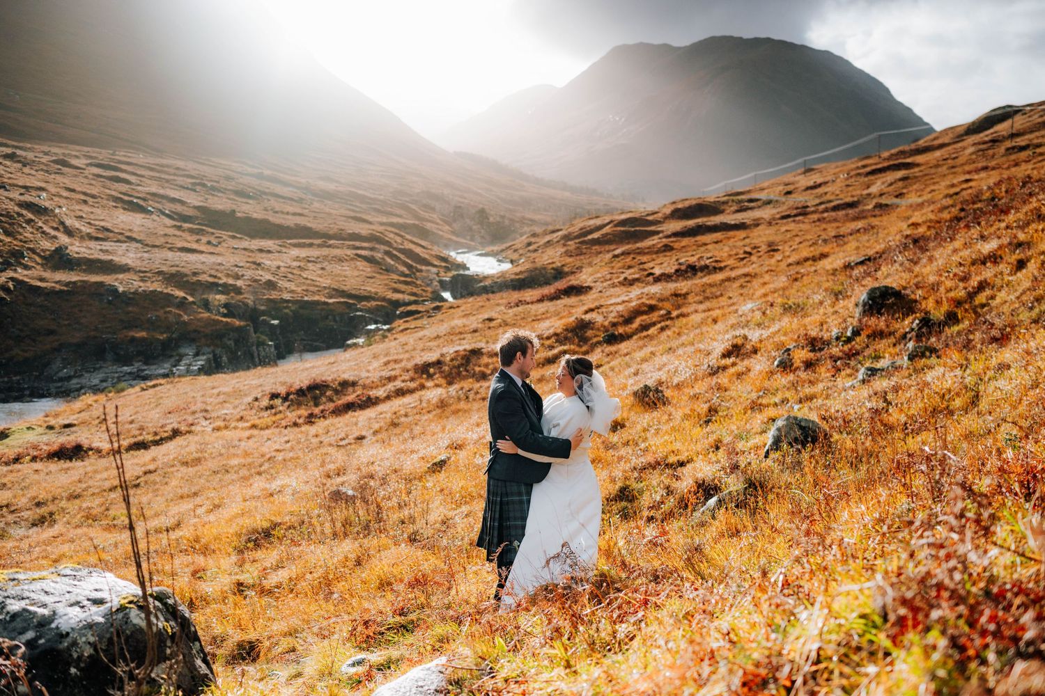 Dramatic mountain landscape with golden autumn colors and misty peaks in the Scottish Highlands.