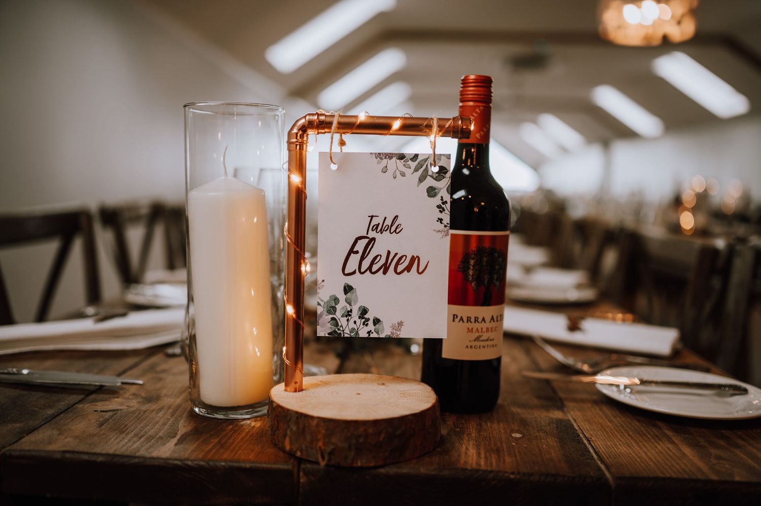 An elegant table setting with wine bottle, menu card, and copper decor elements.