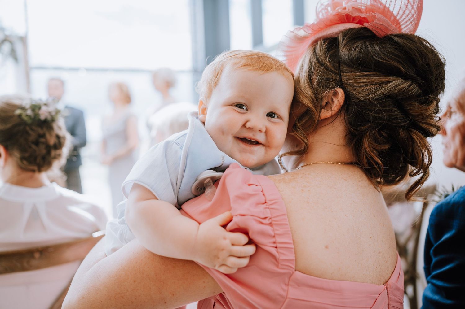 A sweet candid moment of a smiling baby at a wedding celebration.