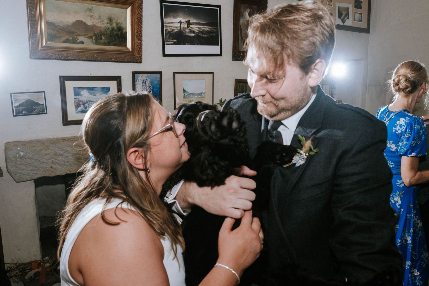 A couple shares a sweet moment with their black cat during their wedding celebration.
