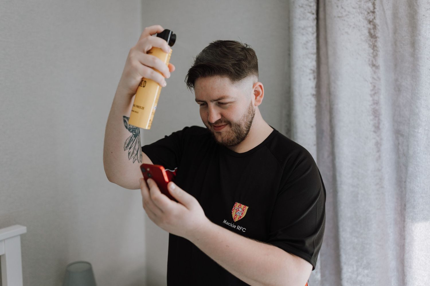 Person in black t-shirt preparing for a special occasion with grooming products.