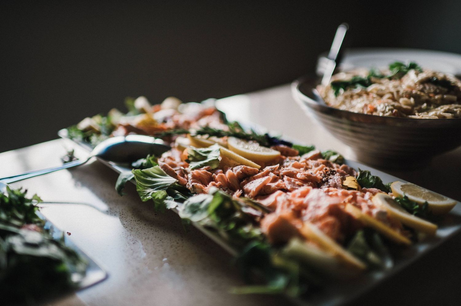 Fresh salad with leafy greens and toppings artfully plated on a dark surface.