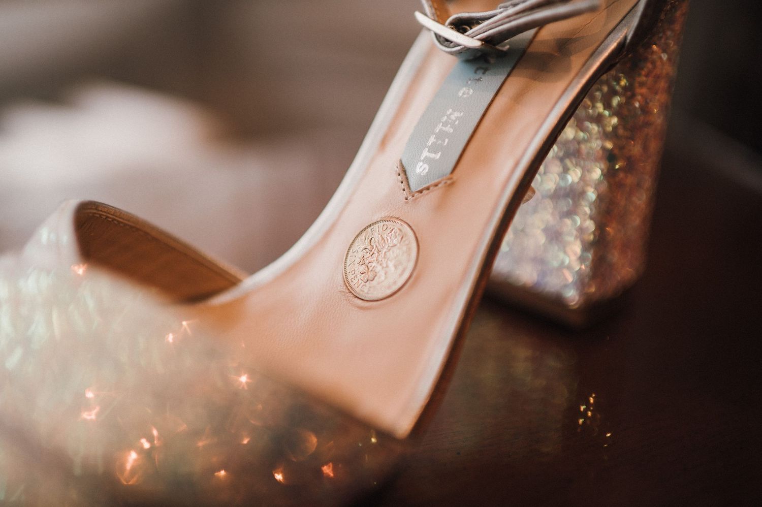 Close-up detail of a sparkly champagne-colored high heel shoe.