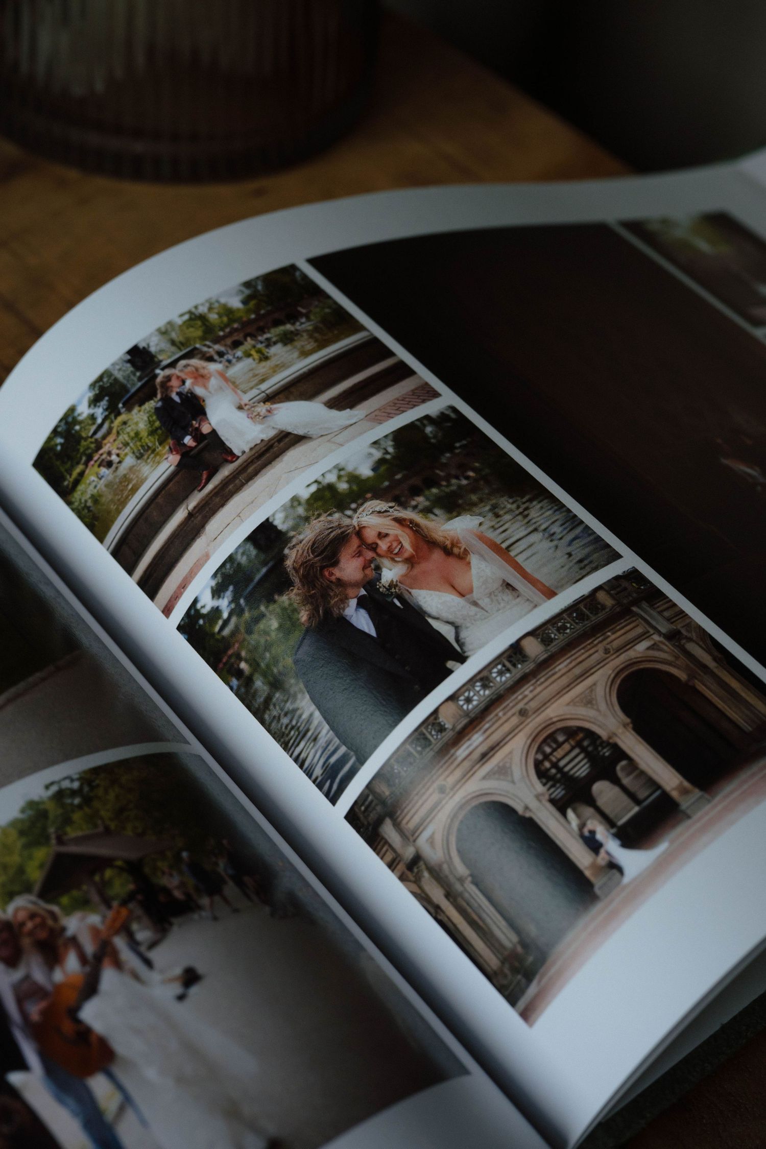 Open wedding photo album showing professional photographs of architectural venues.