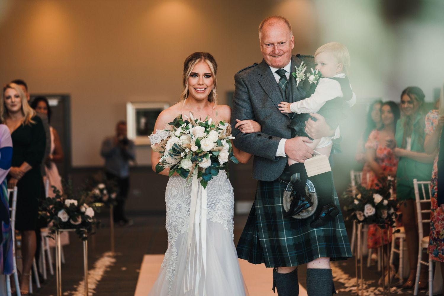 Traditional Scottish wedding processional with bride in white gown and escort in kilt.