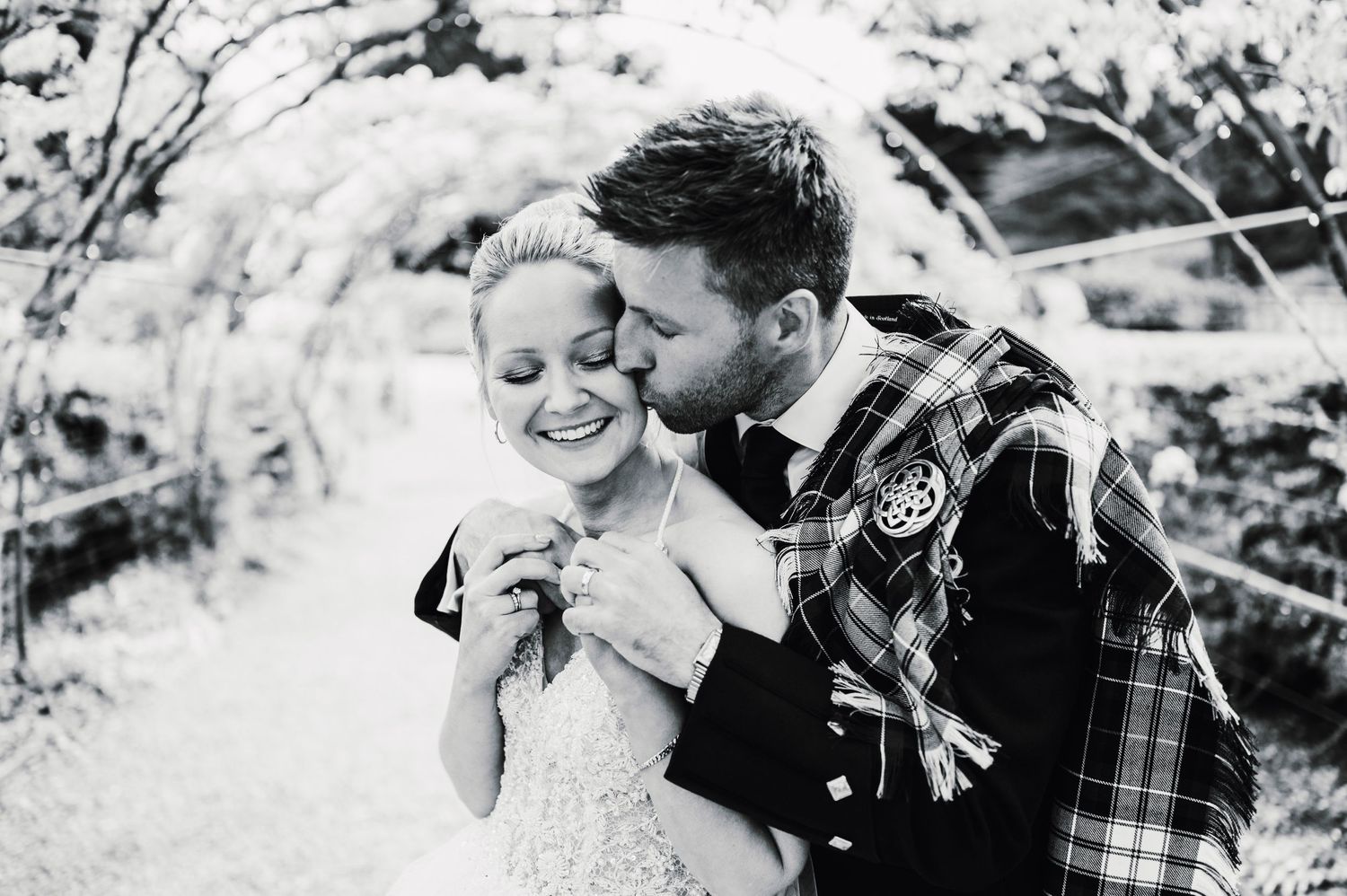 Romantic black and white portrait of a couple in formal attire outdoors.