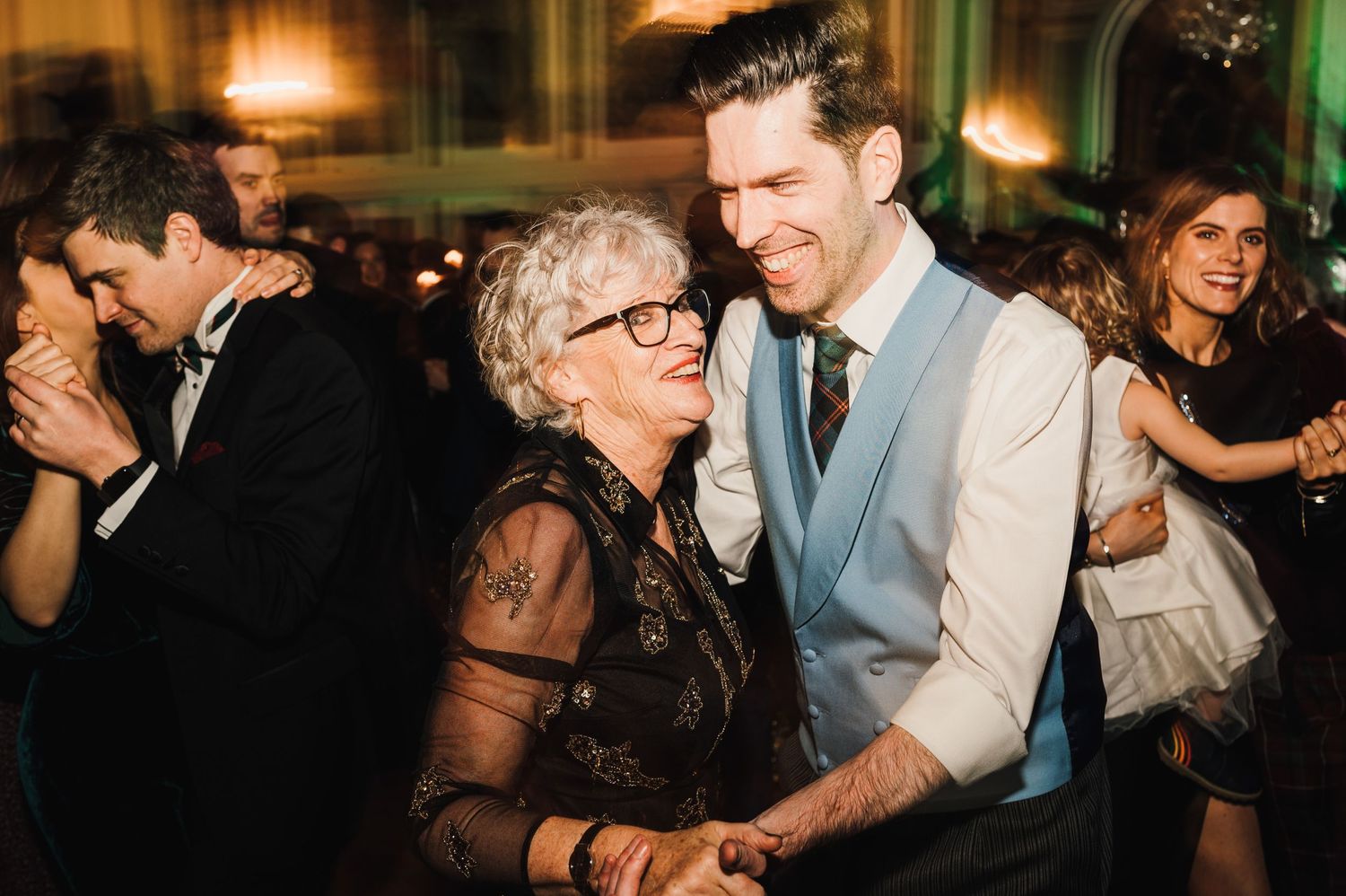 Wedding guests share a heartfelt dance moment at an elegant indoor reception venue.