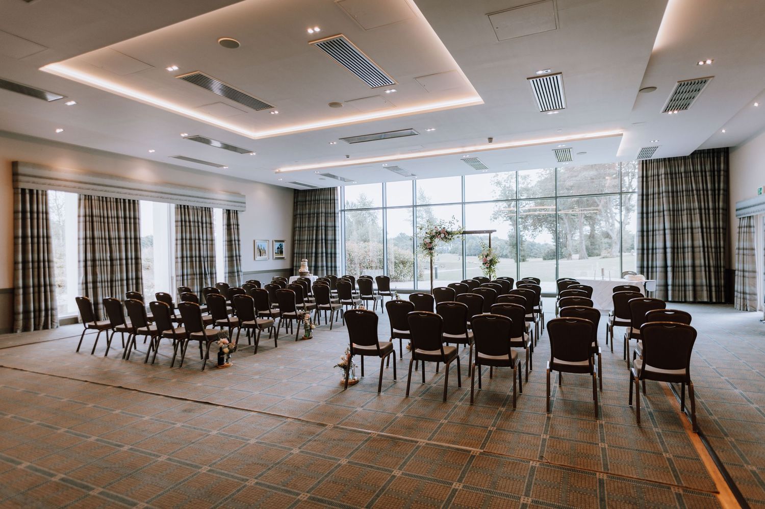 Modern conference room set up with rows of chairs and recessed lighting.