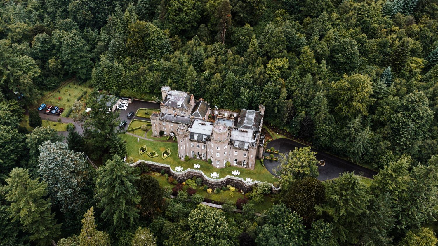 Aerial panoramic view of a luxury resort property nestled among lush green forest trees.