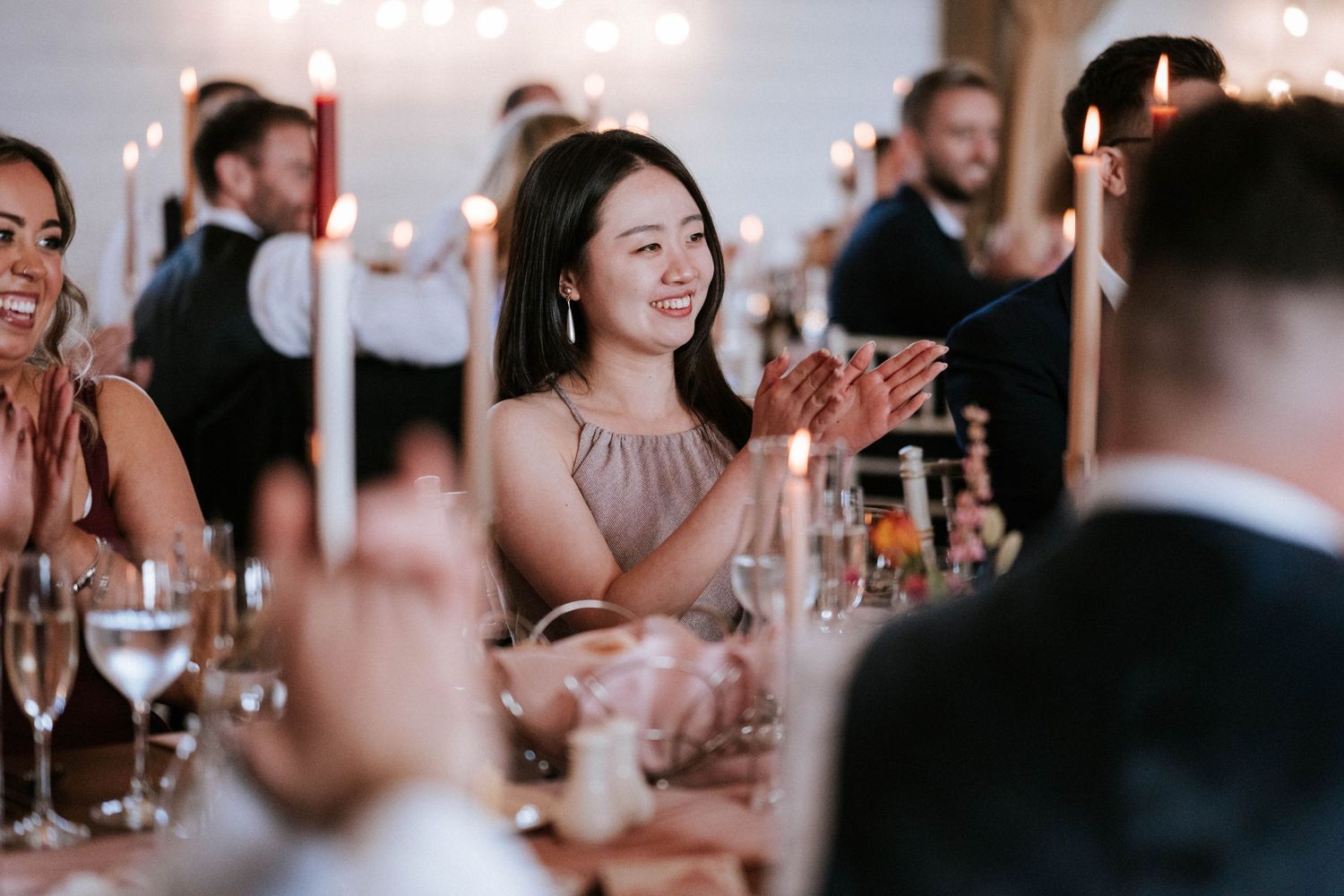 Wedding reception guests enjoying dinner and conversation at an elegantly decorated table.