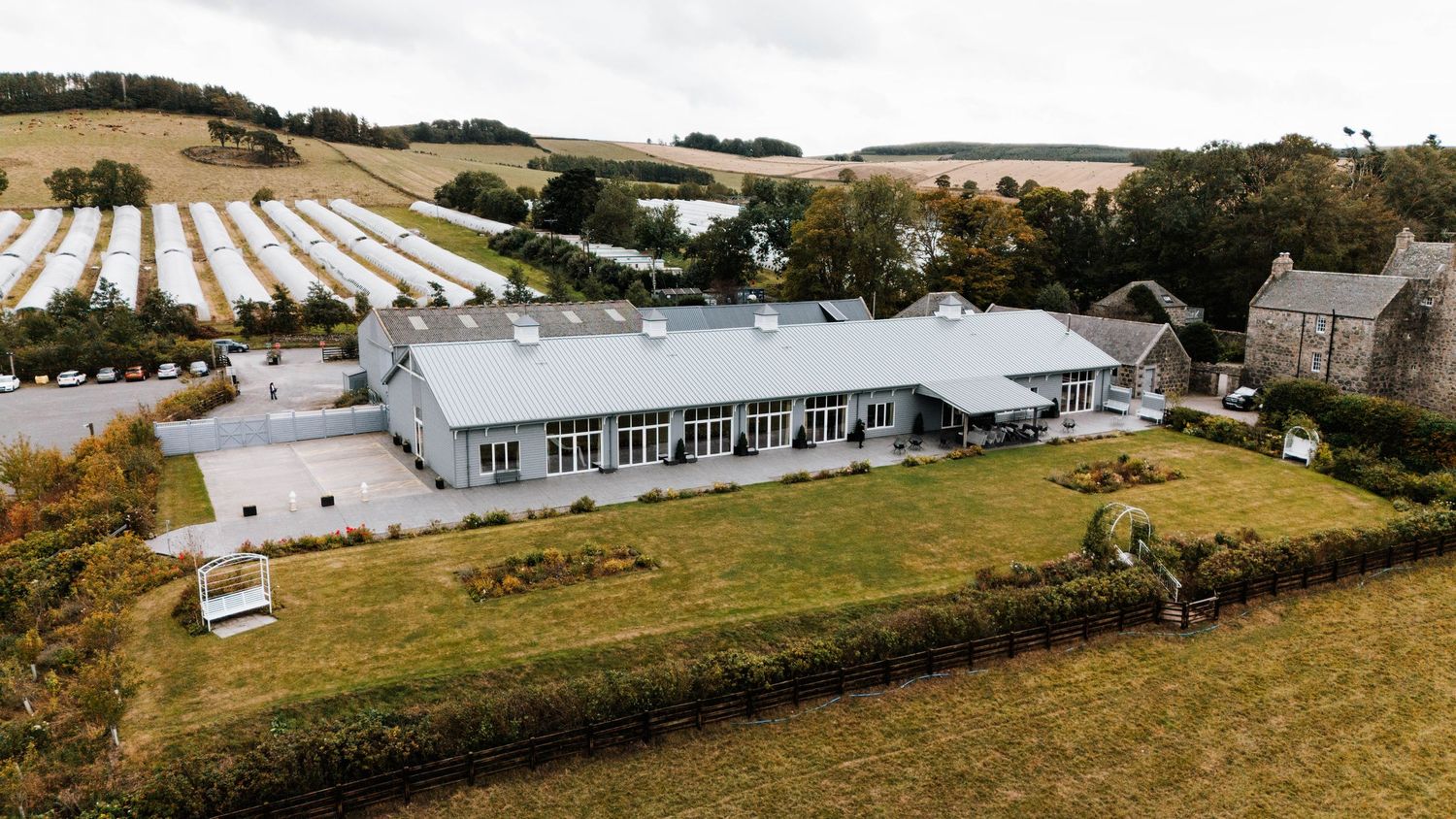A scenic panoramic view of rolling farmland with green fields, barns, and buildings stretching across the countryside.
