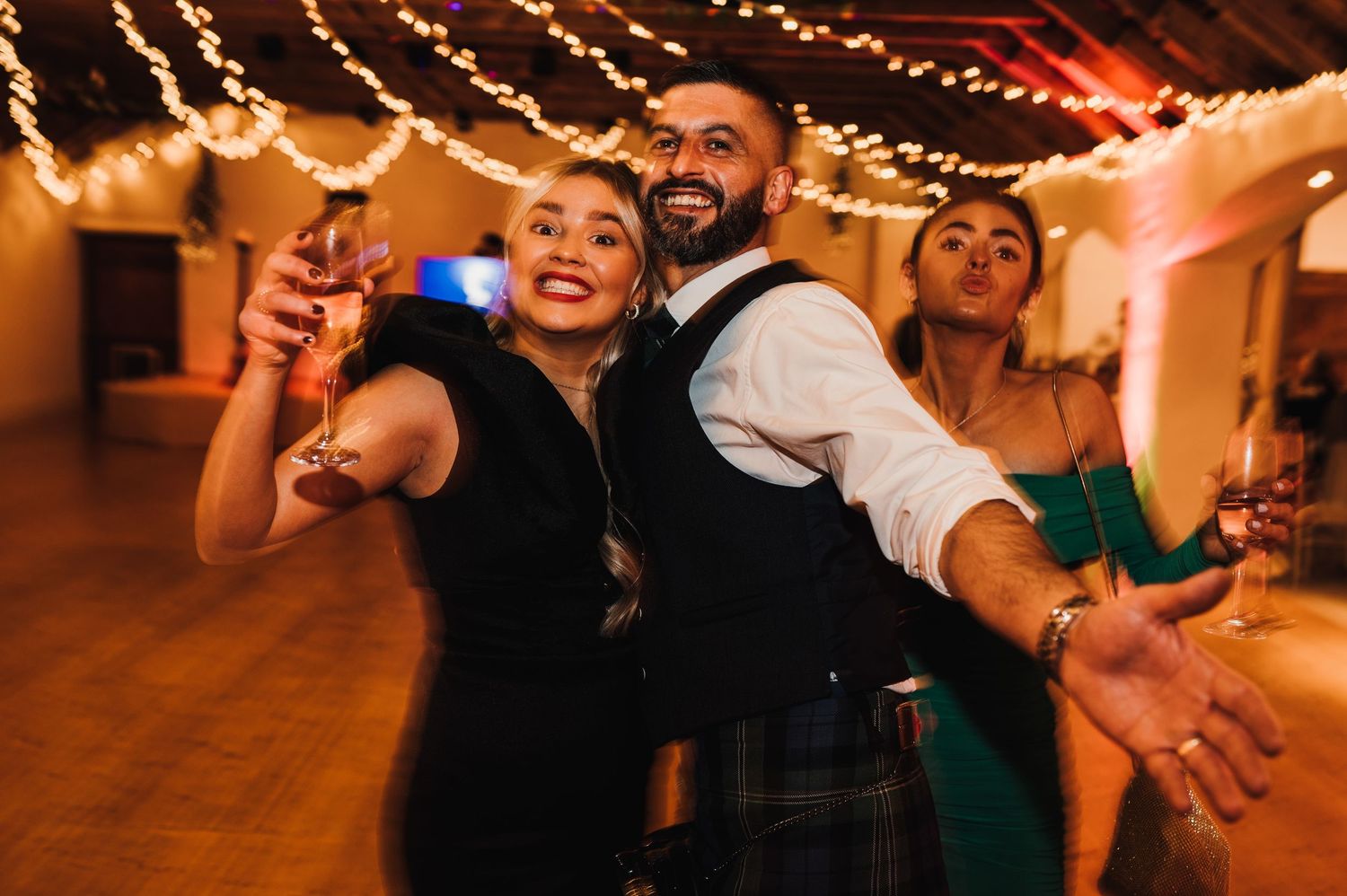 Wedding reception dance floor with string lights creating a warm, festive atmosphere.