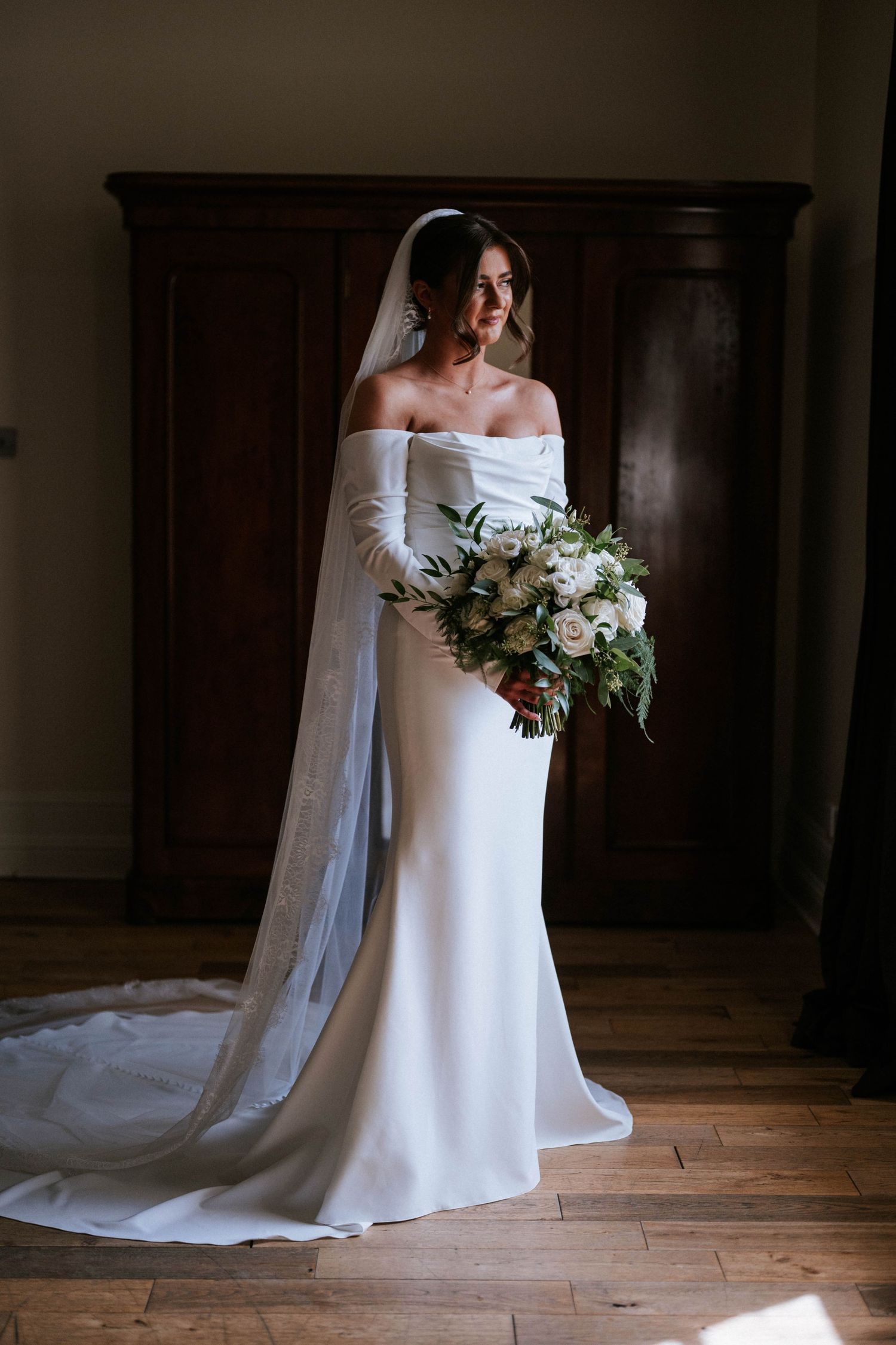 Aberdeen Wedding Photography. Elegant white wedding dress with flowing train displayed in classic interior.