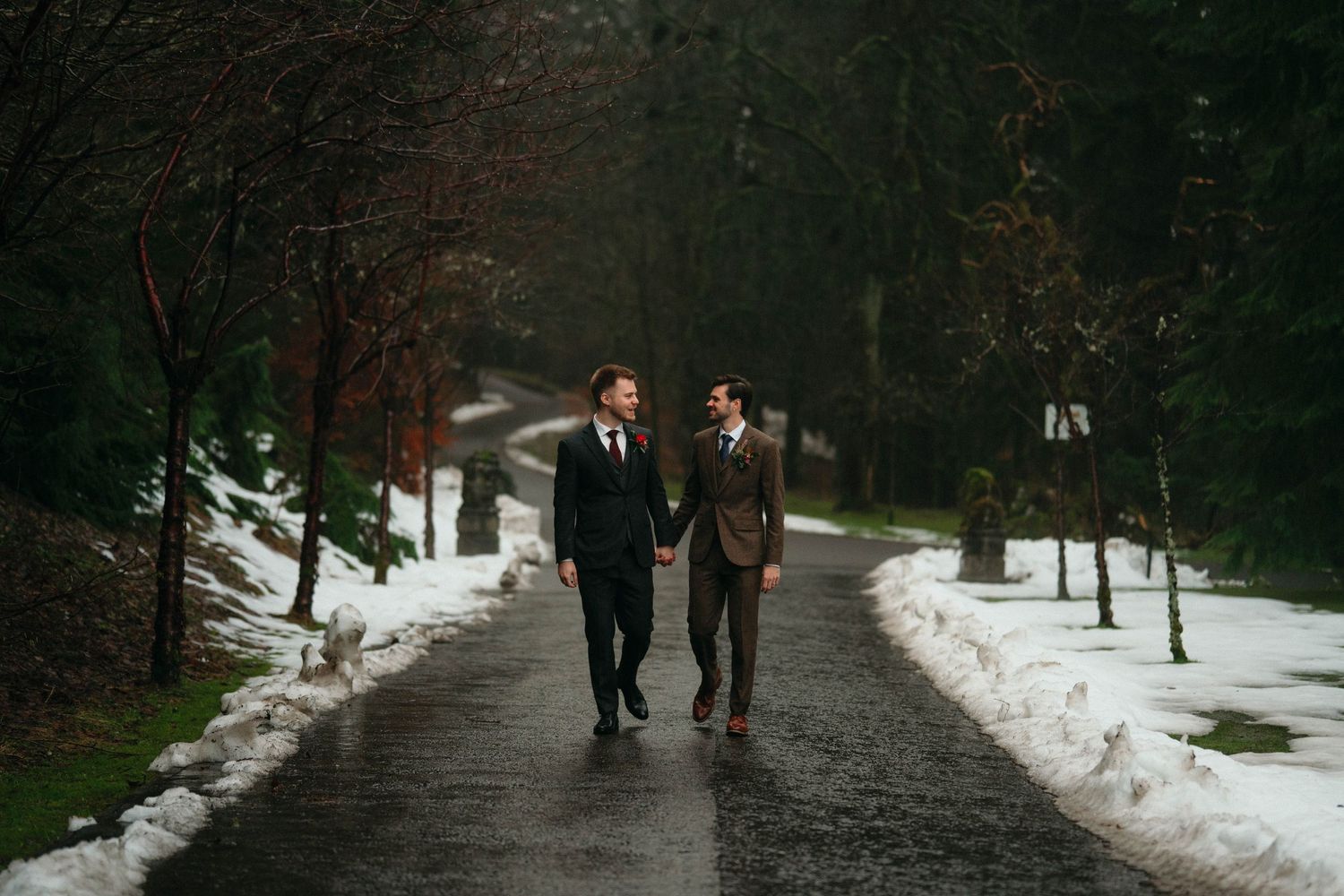 Drumtochty Castle  Wedding Photography. People walking along a snowy path surrounded by bare winter trees.