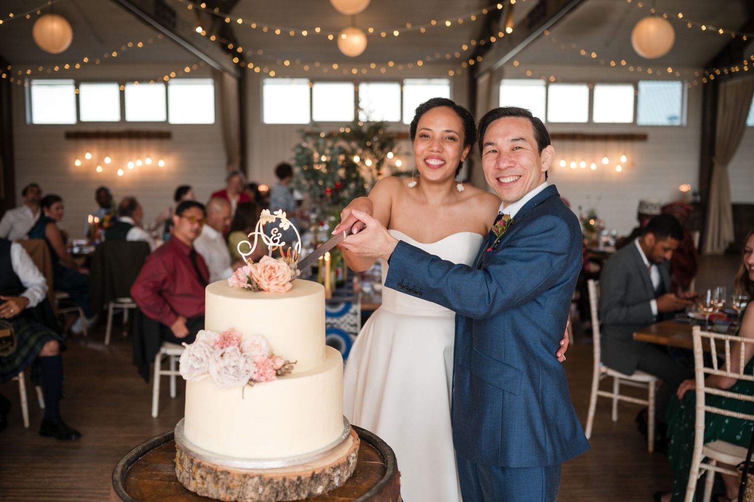 Wedding venue interior with white chairs and hanging string lights creating a romantic atmosphere.