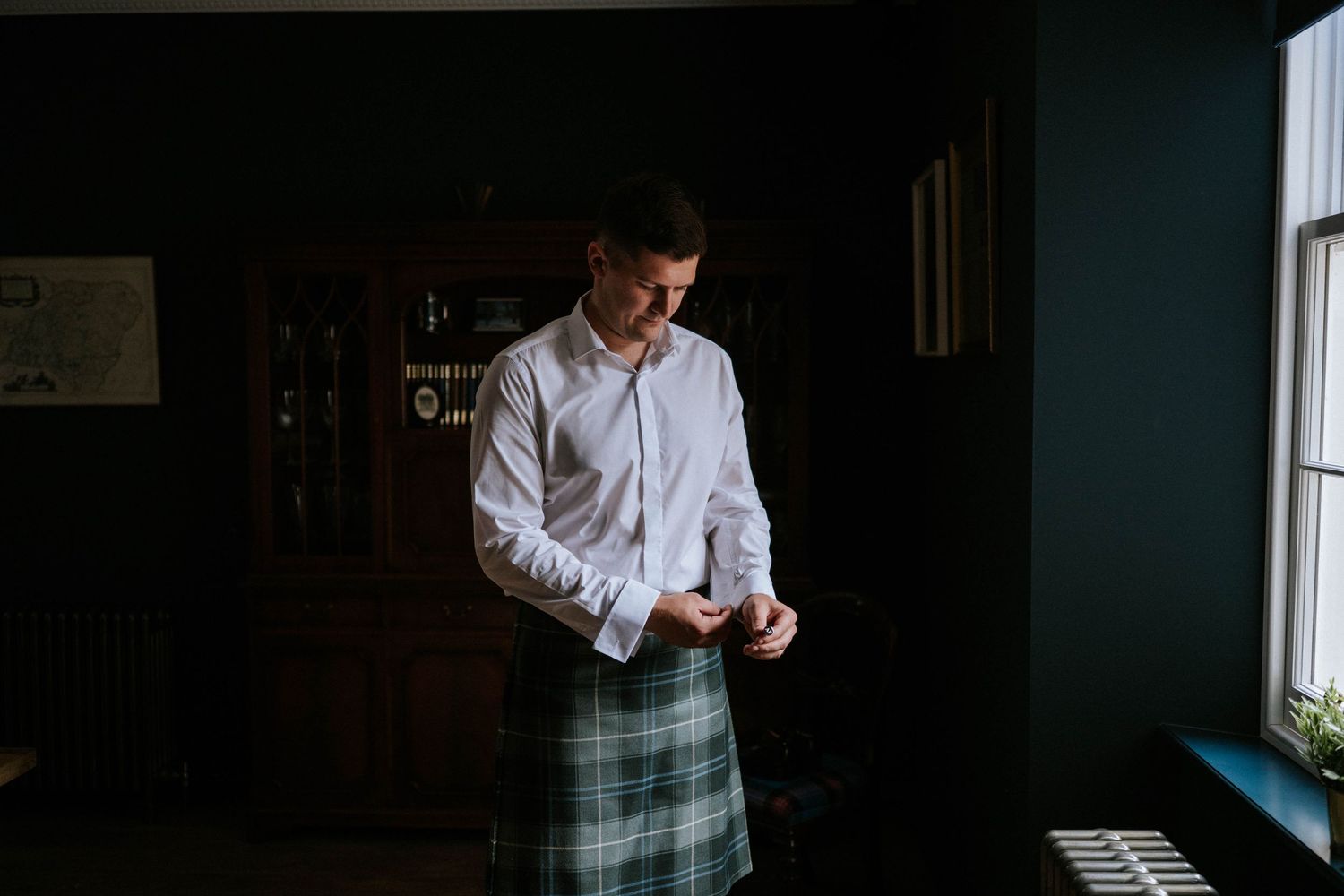 Dark moody getting ready scene with light coming through windows.