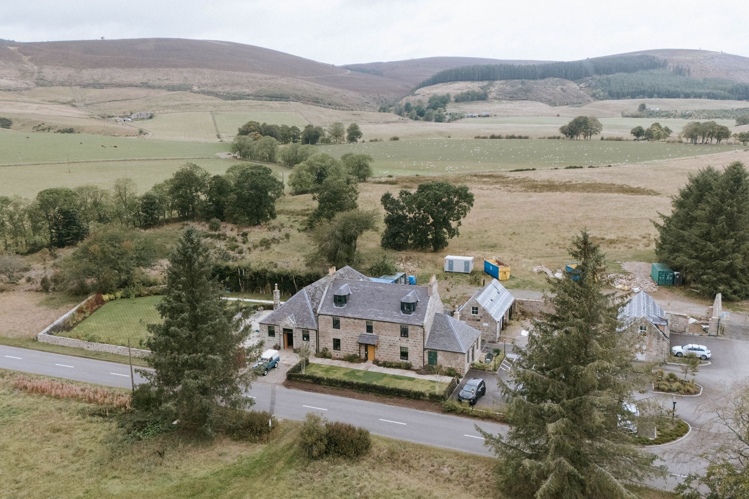 Rolling hills and countryside landscape with scattered buildings and roads winding through pastoral farmland.