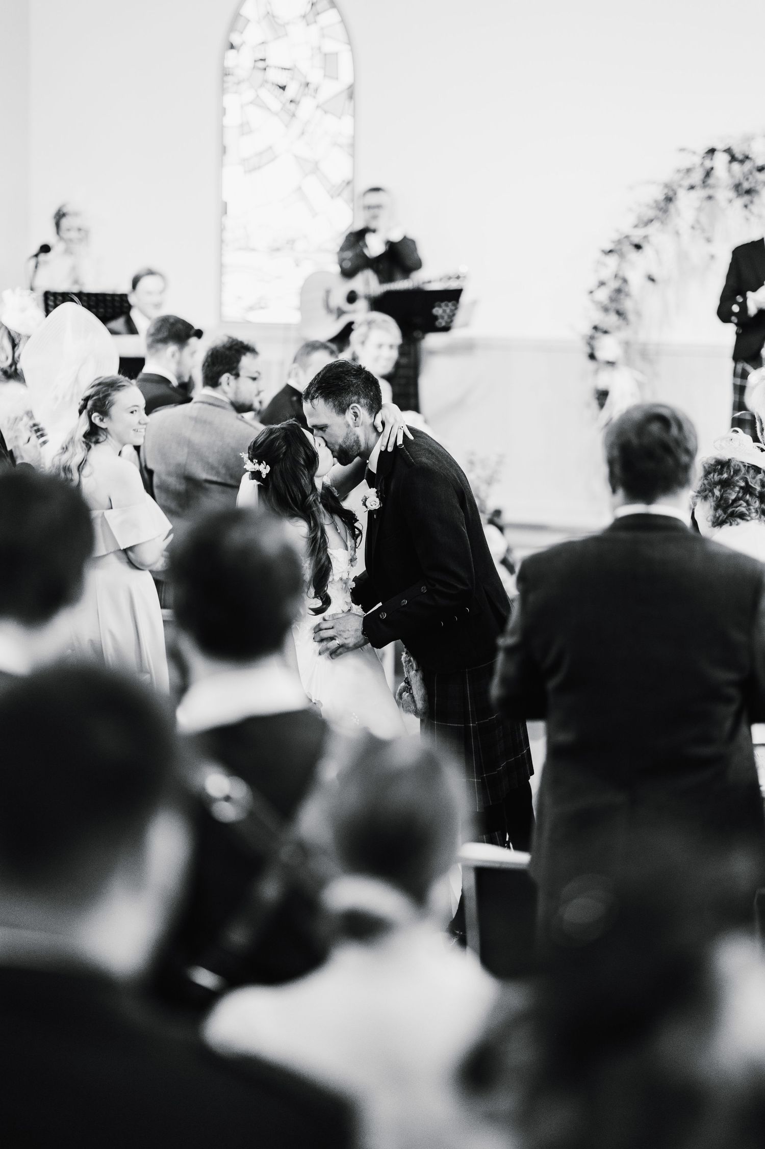 Black and white photo of a wedding ceremony in progress inside a traditional church setting.