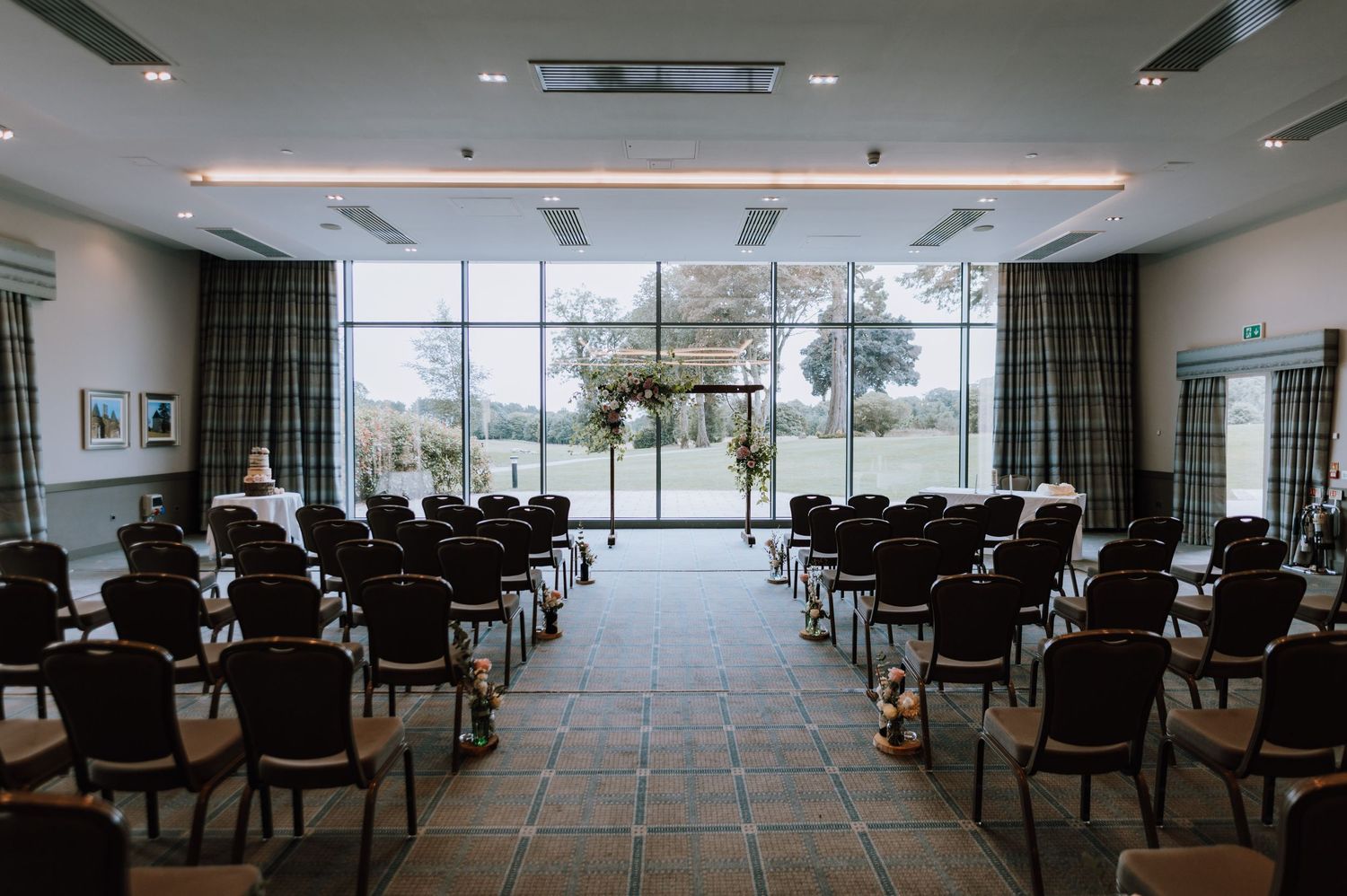 Modern ceremony room with rows of chairs and floor-to-ceiling windows.
