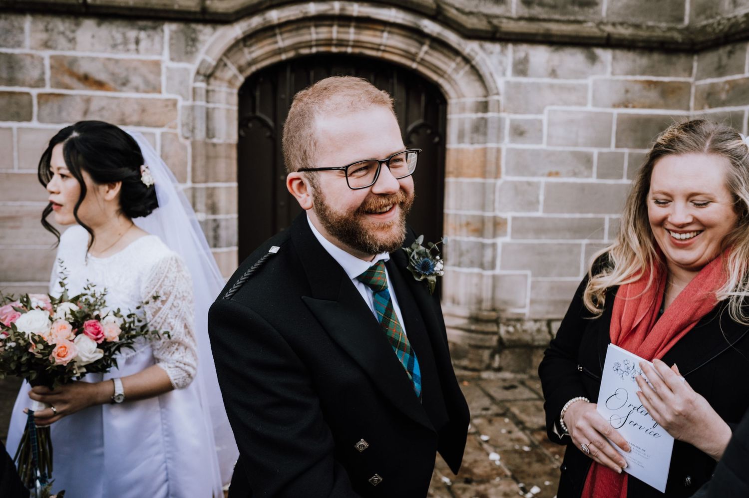 Candid moment of laughter and joy during outdoor wedding celebrations.