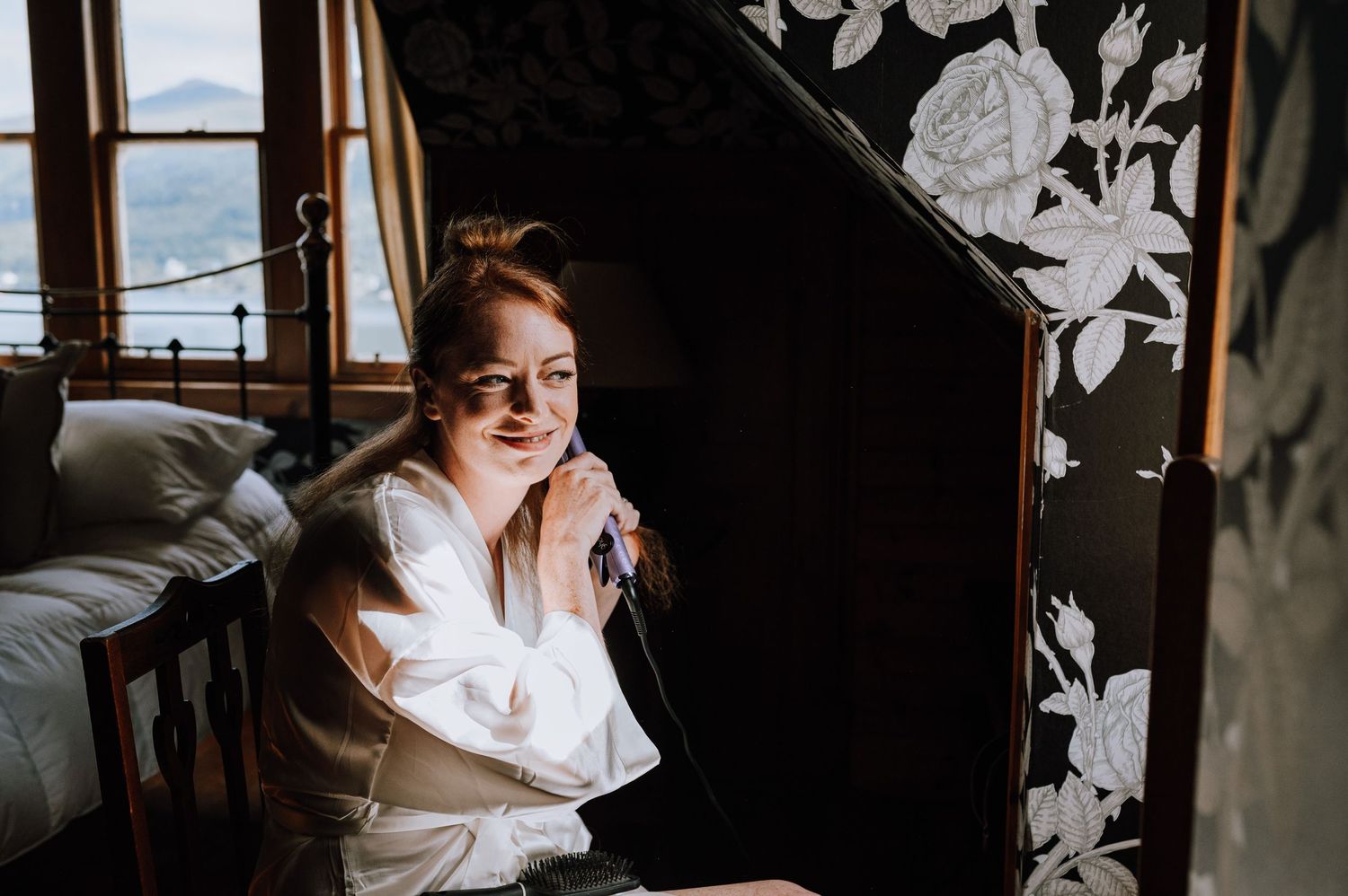 Elegant bridal preparation scene with floral wallpaper backdrop.