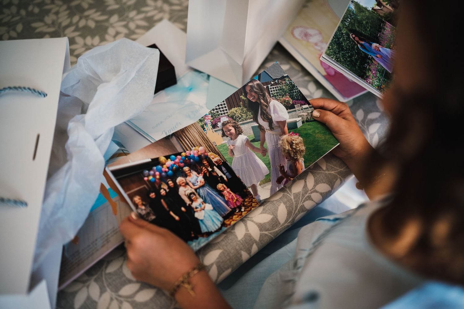 Someone looking through old photographs and memories during wedding preparations.