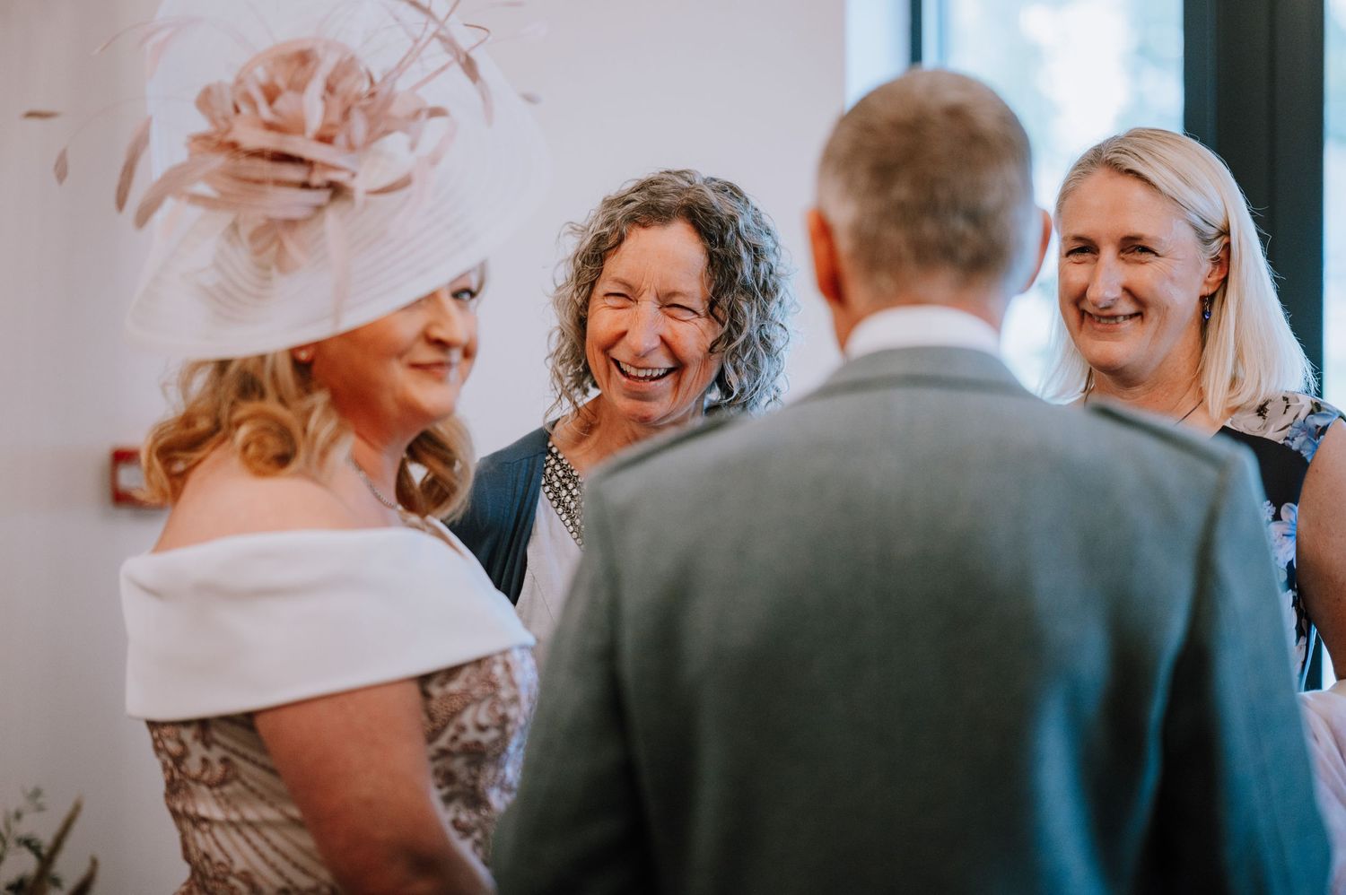 Wedding guests share a joyful moment of laughter during the ceremony celebration.