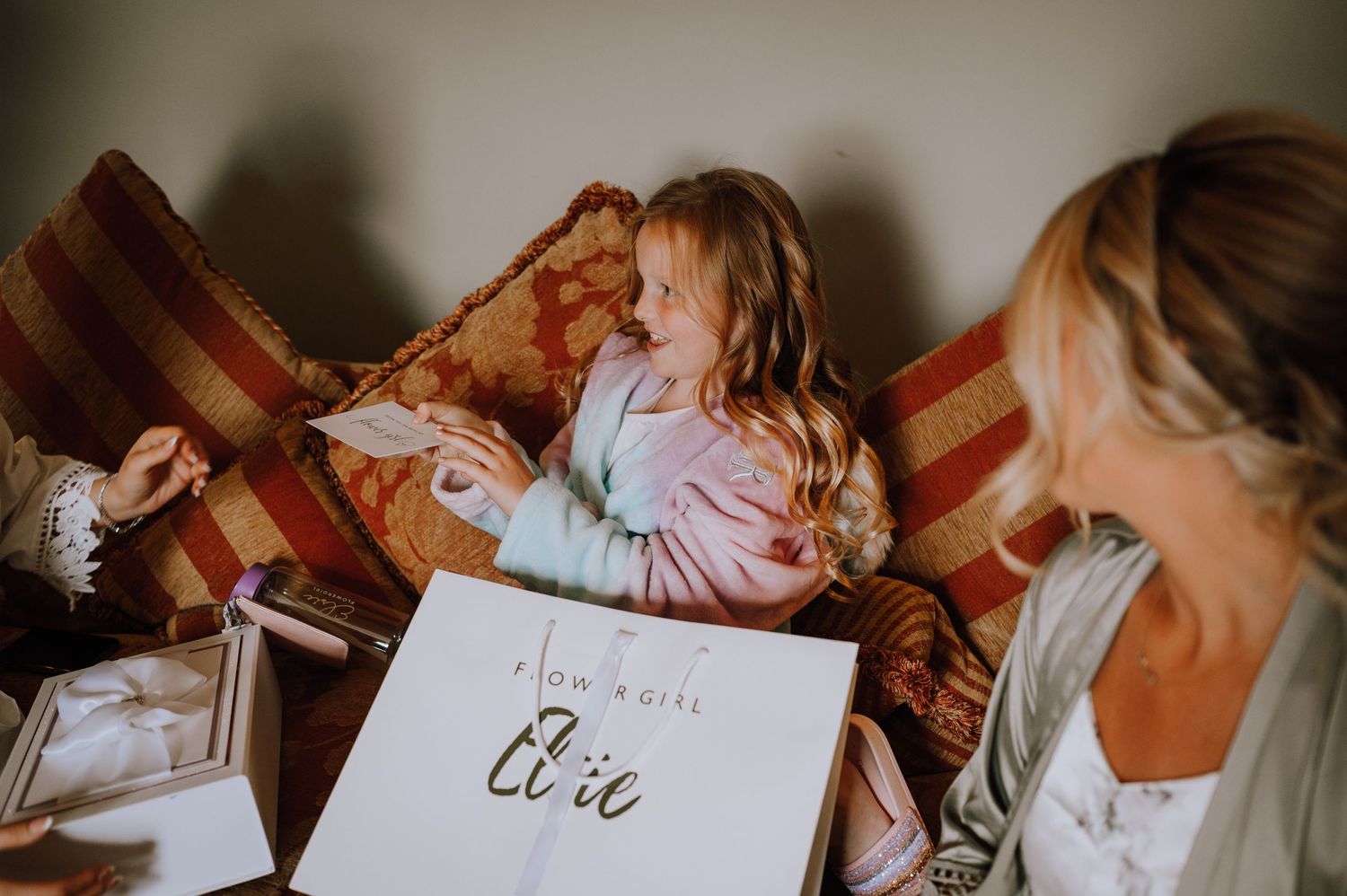People gather on a couch while looking at wedding preparation items and signage.